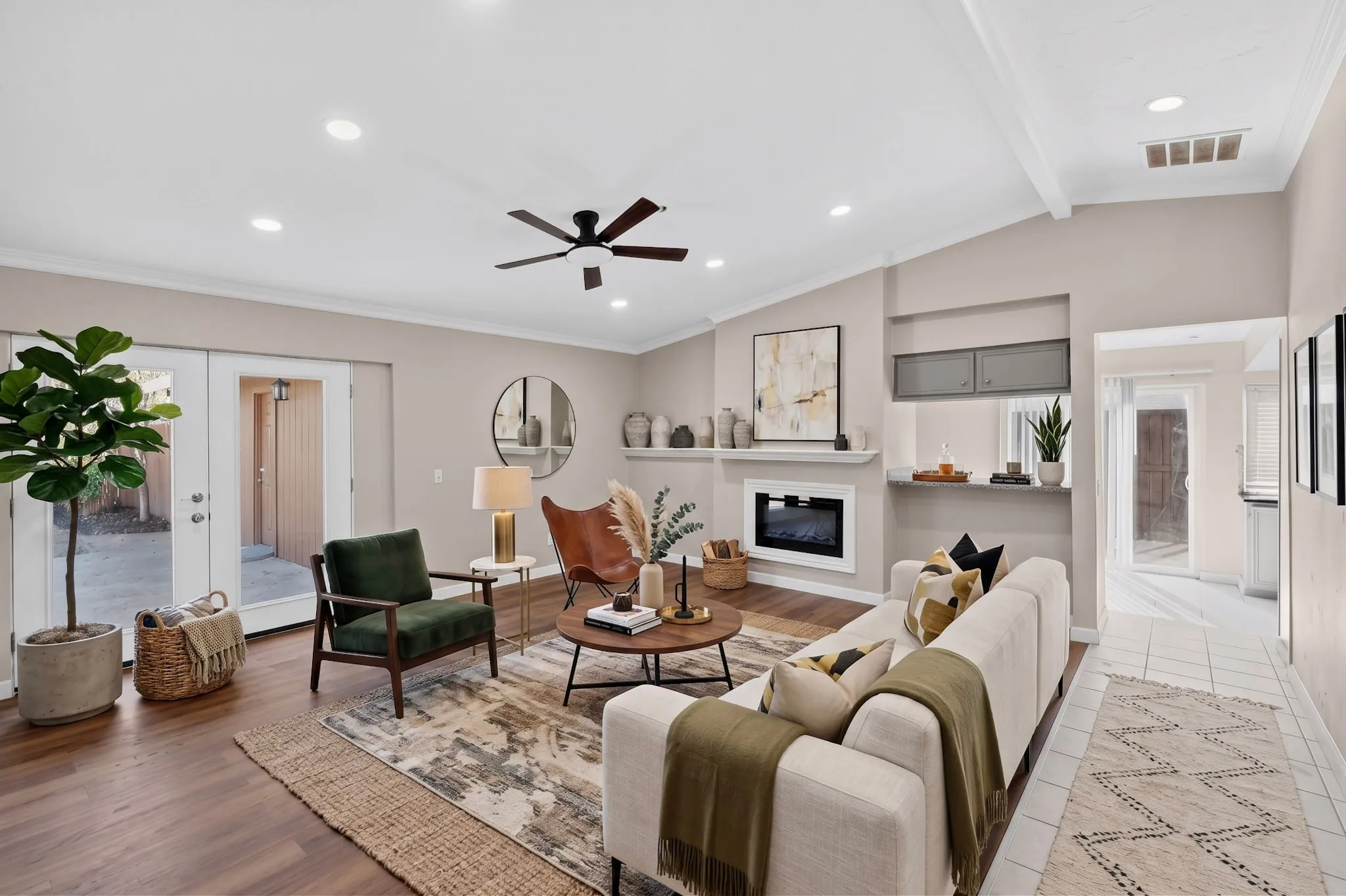 Vaulted ceiling with exposed beams, recessed lighting, wood-finish flooring, built-in fireplace, and double French doors leading to an exterior space