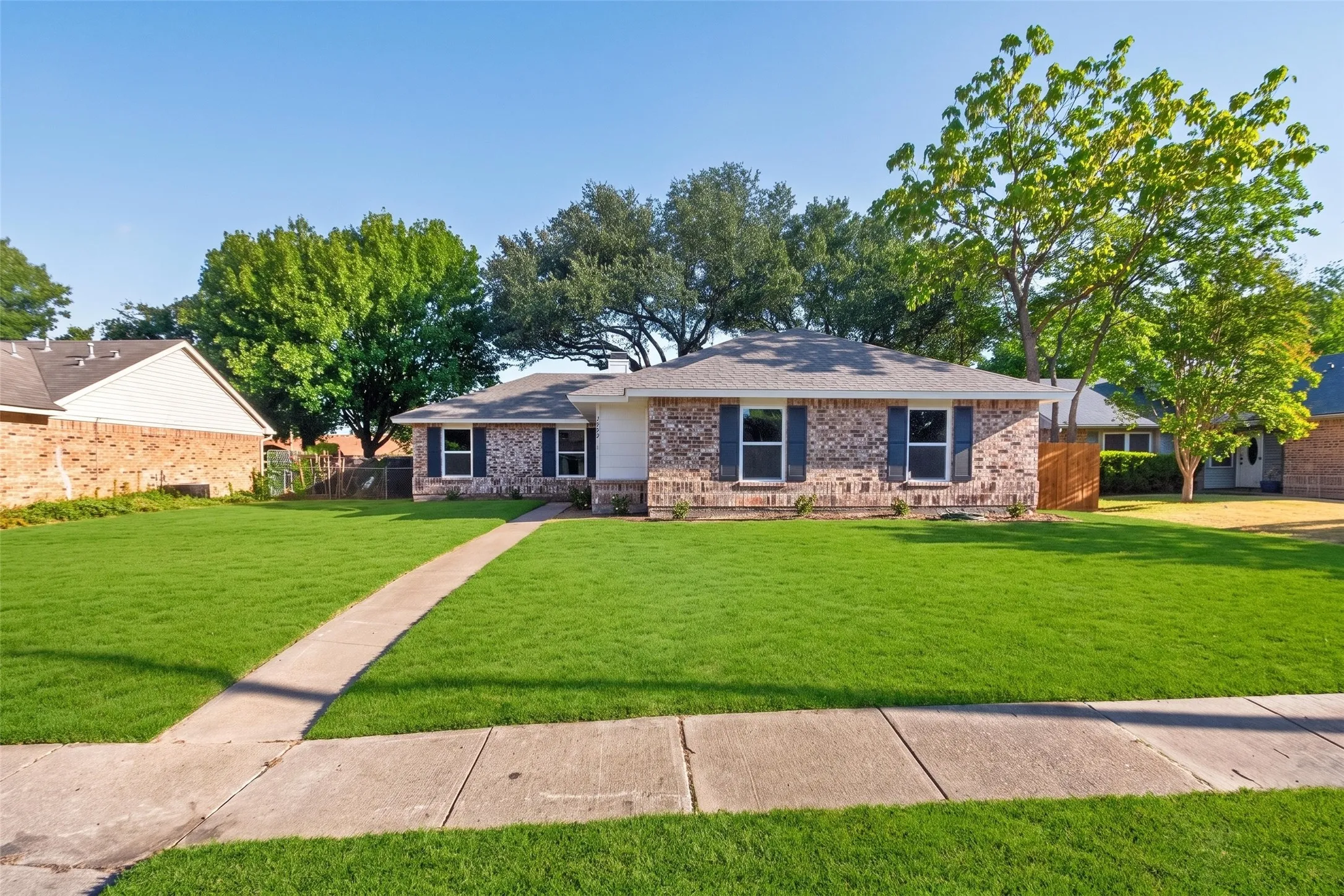 Brick exterior with white siding accents and dark shutters