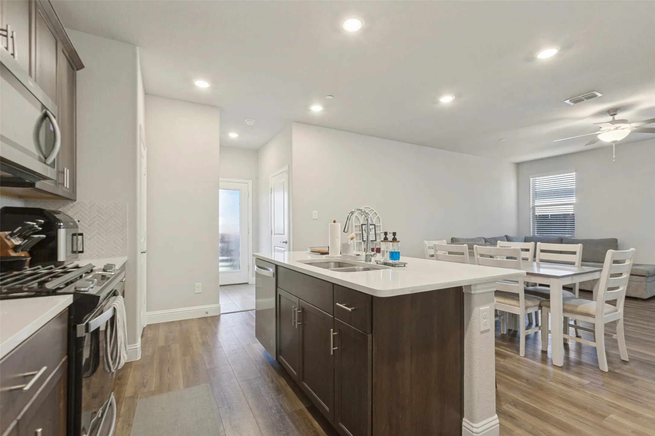 Gourmet kitchen with stainless steel appliances, wood-finish flooring, and recessed lighting