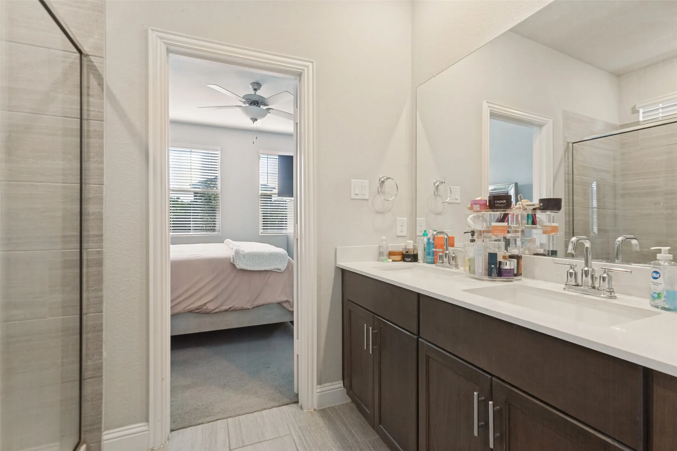 Dual vanity with white countertops, dark wood-finish cabinetry, and chrome fixtures