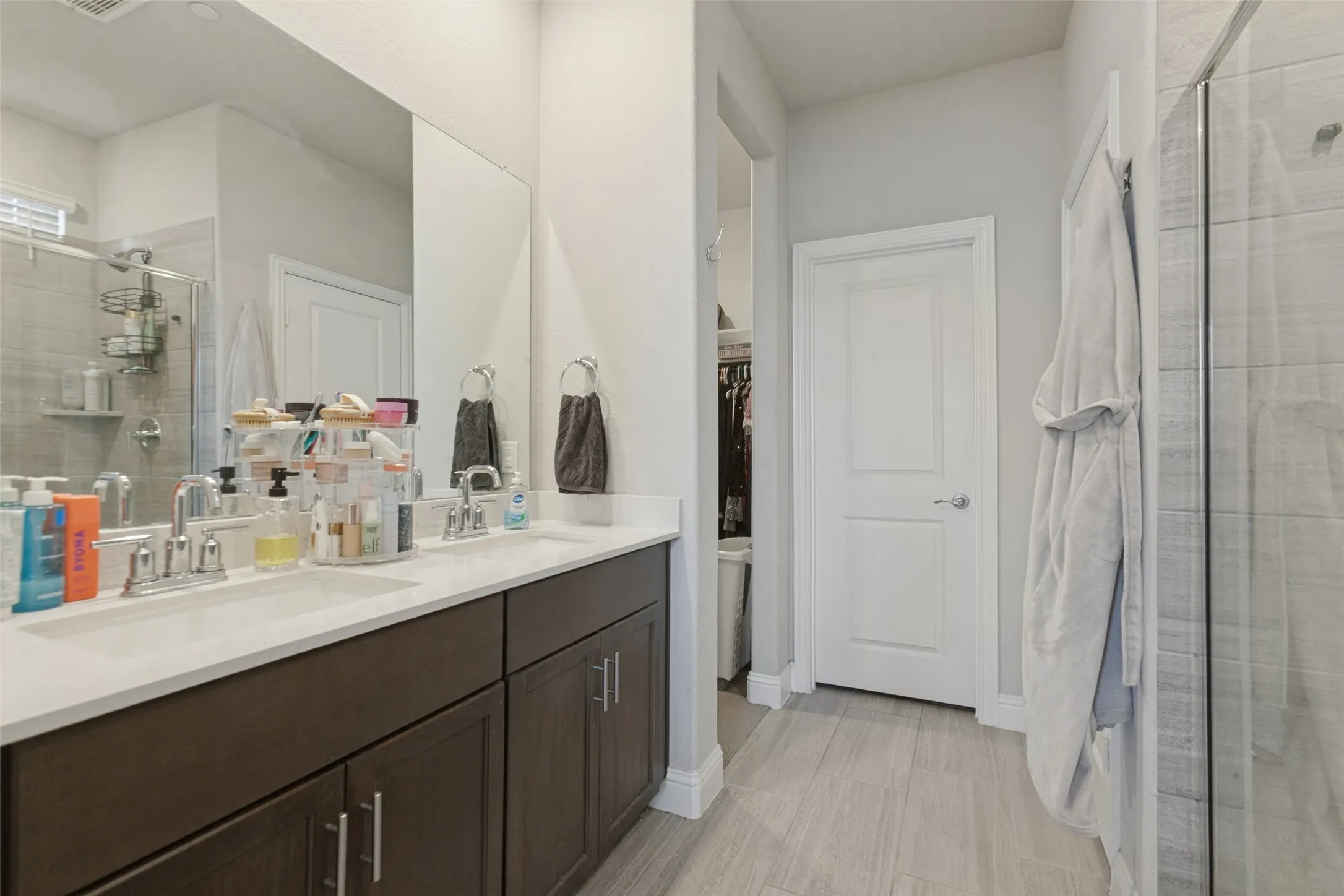 Double vanity with undermount sinks, chrome fixtures, and dark wood-finish cabinetry