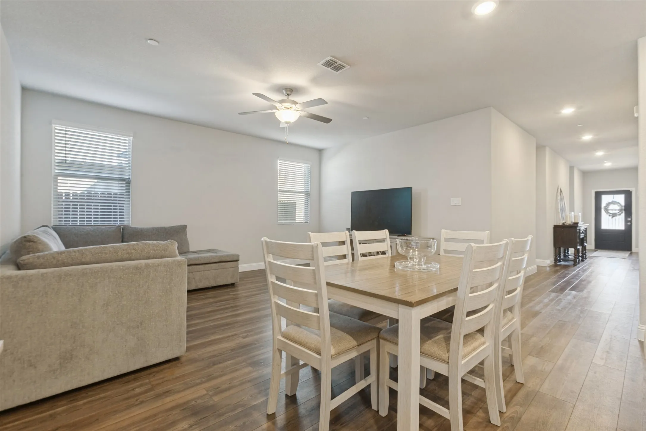 Open-concept living space featuring wood-finish flooring, recessed lighting, and a ceiling fan