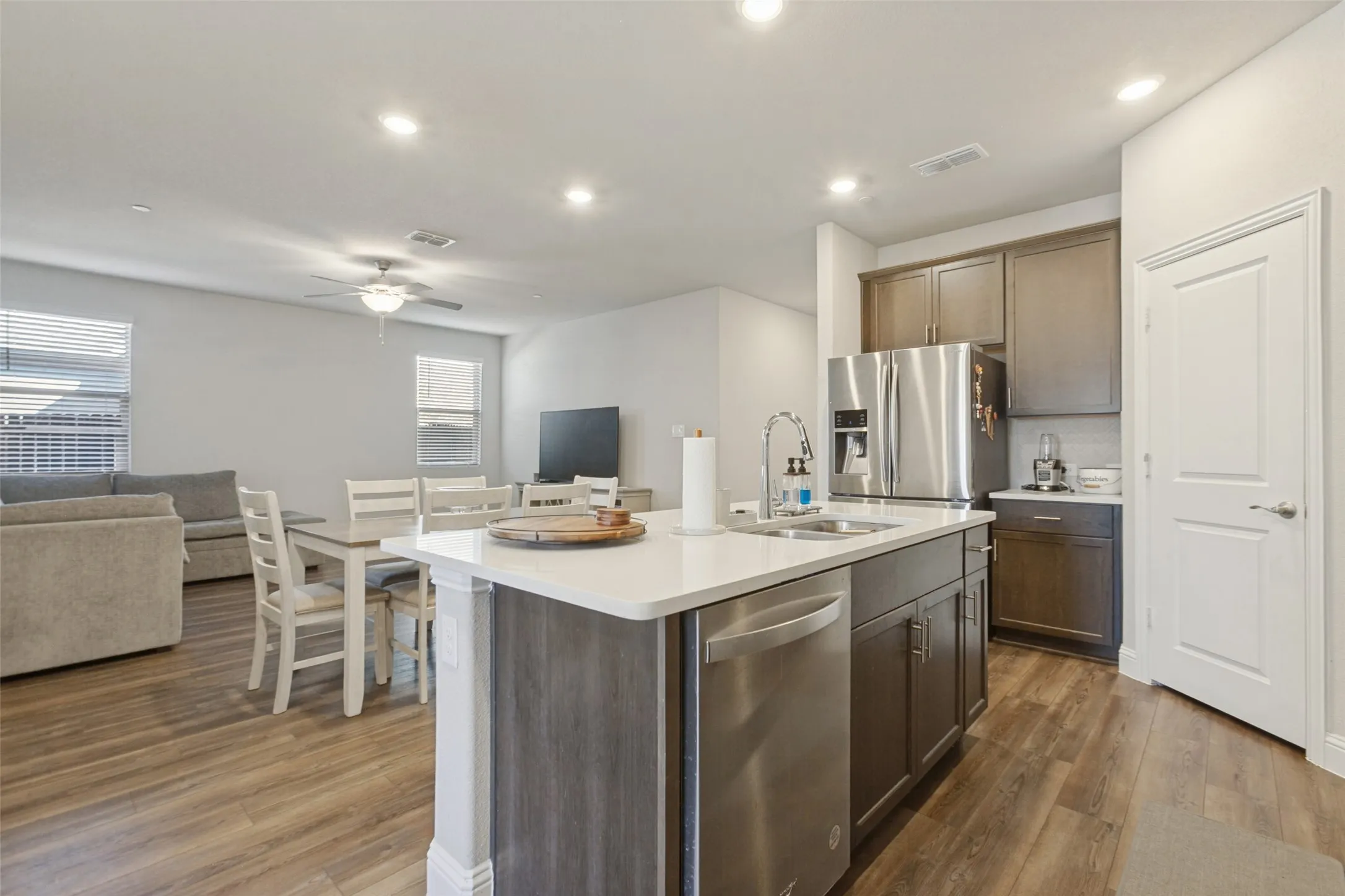 Open-concept living area featuring wood-finish flooring, recessed lighting, and a ceiling fan
