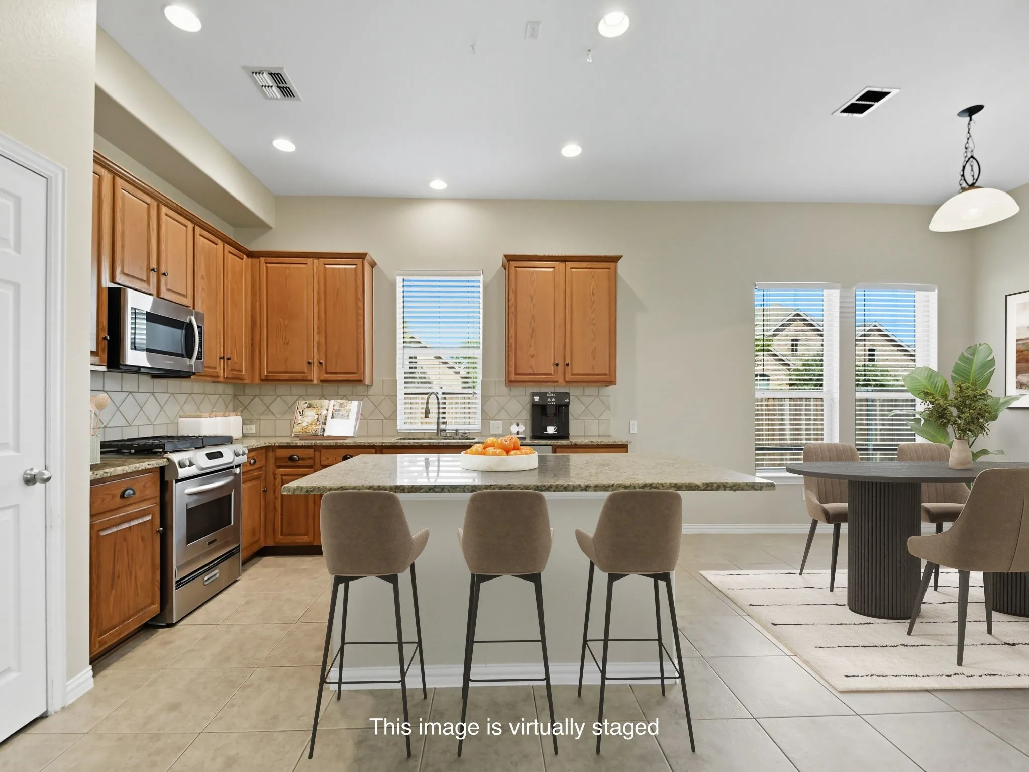 Kitchen featuring wood cabinetry, stainless steel appliances, a multi-tone tile backsplash, and a central island with a light-colored countertop