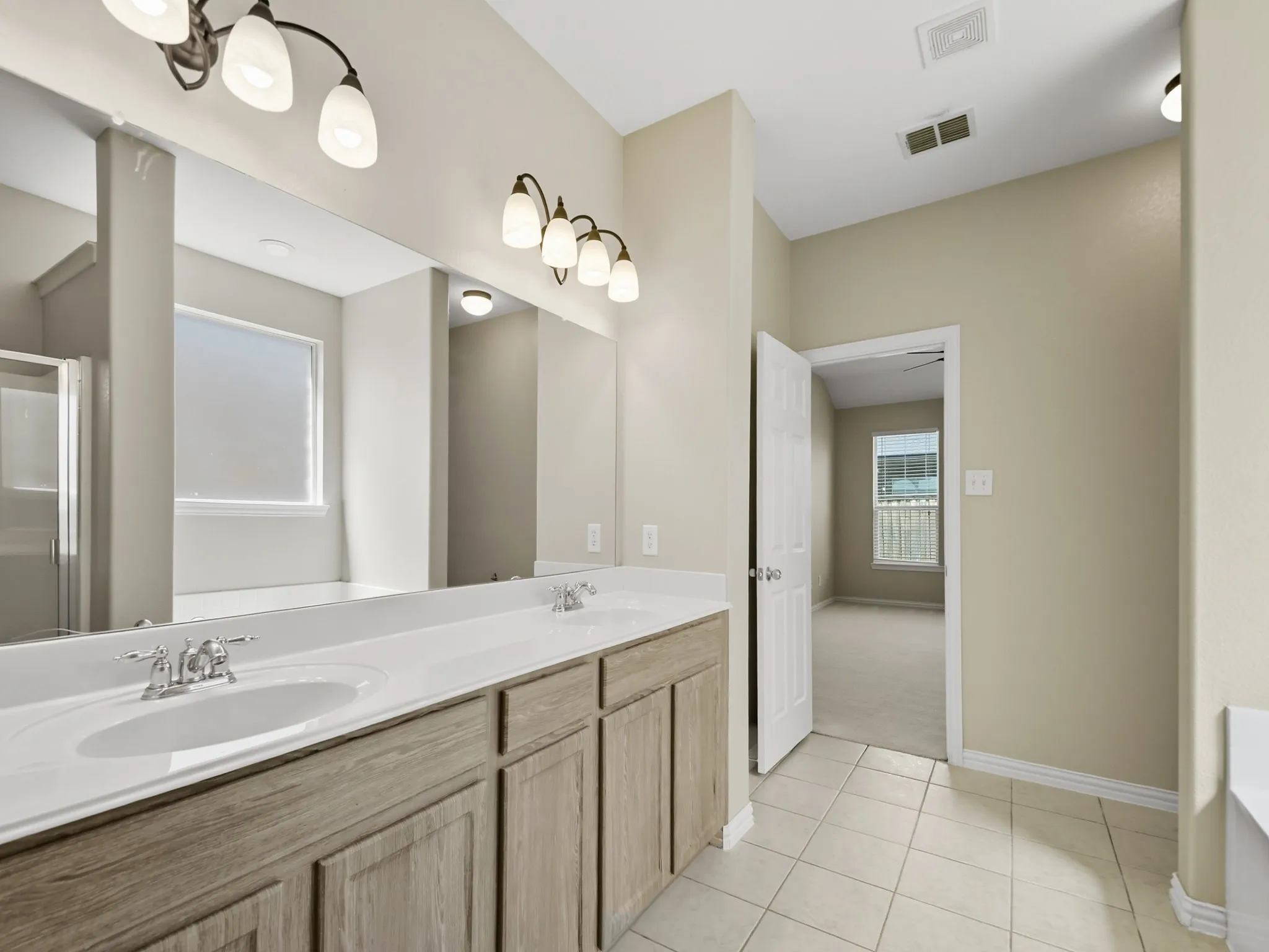 Primary Bathroom w Dual vanity with undermount sinks, wood-finish cabinetry, and brushed nickel fixtures