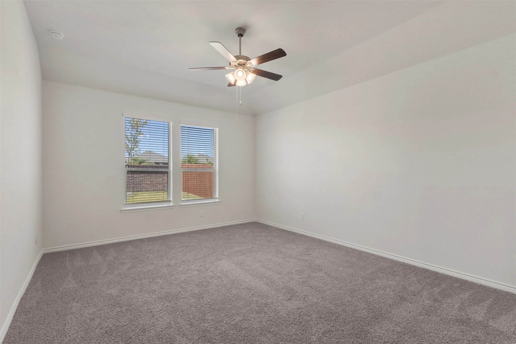 Recessed lighting, ceiling fan with light fixture, dual windows with blinds, and neutral tone carpet