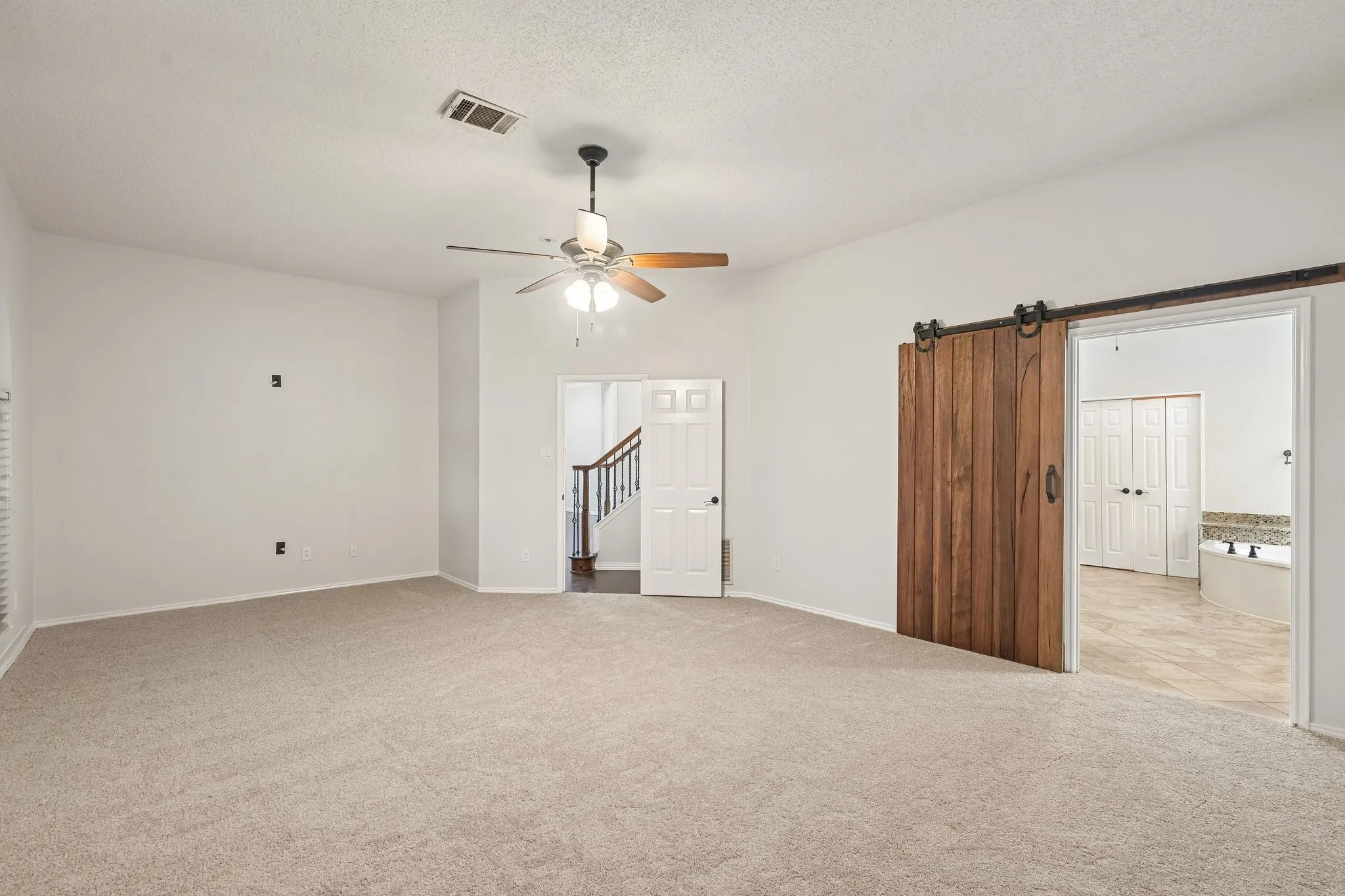 Primary bedroom with barn door & ensuite bathroom
