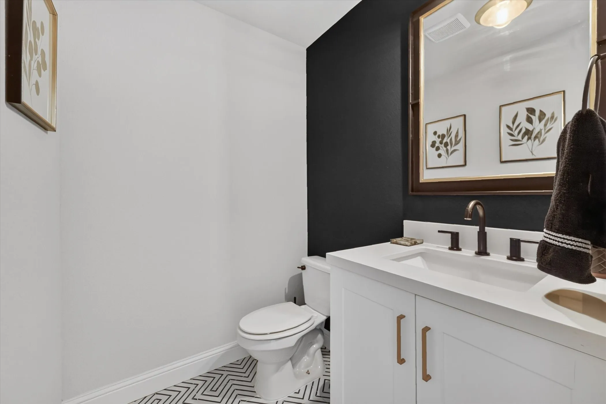 White vanity with bronze-finish hardware, a white countertop, and a bronze-finish faucet