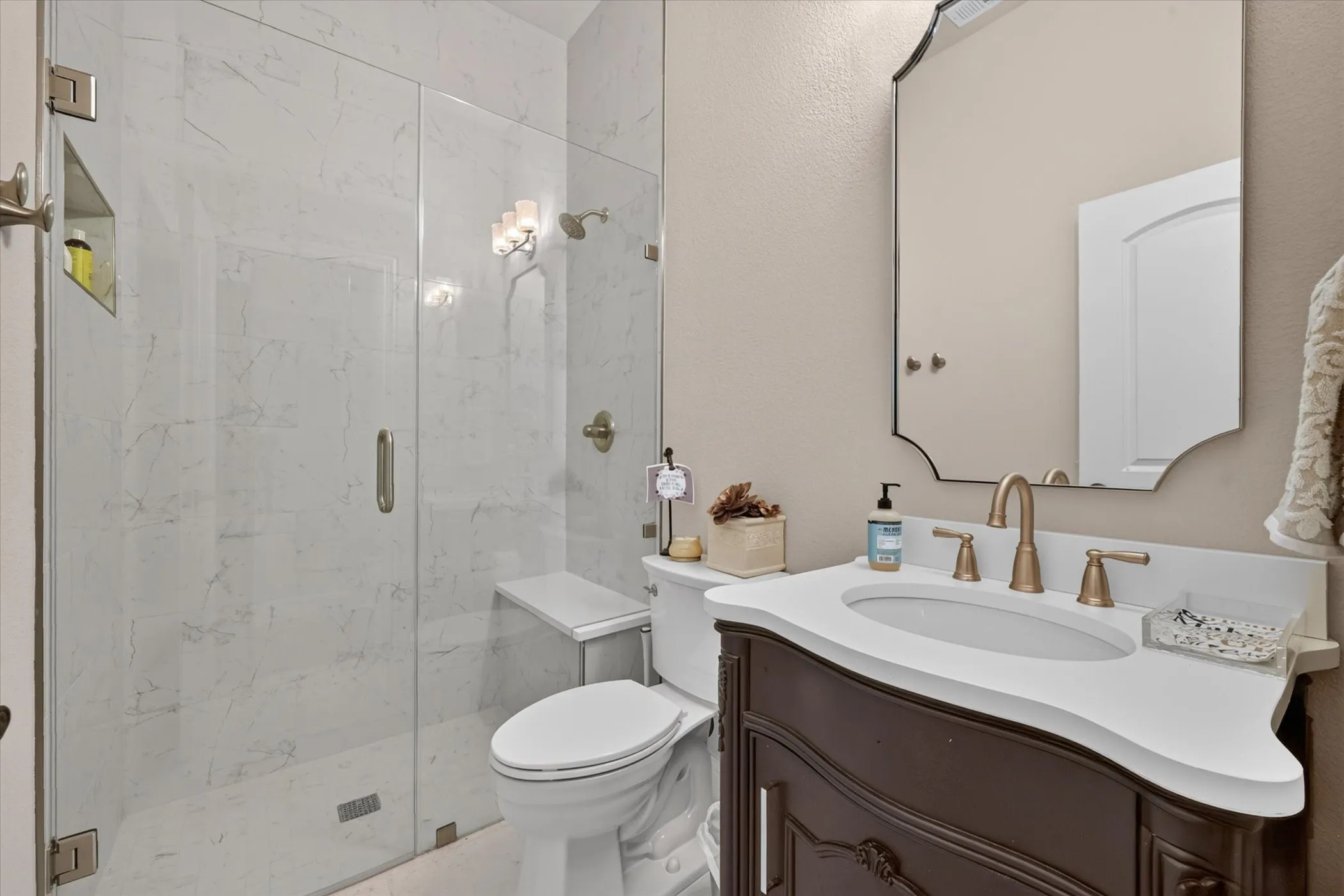 Glass-enclosed shower with a built-in bench and recessed niche