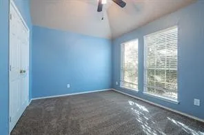 Unfurnished bedroom with lofted ceiling, baseboards, and carpet flooring