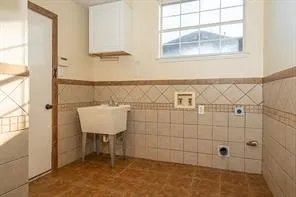 Washroom featuring tile walls and wainscoting
