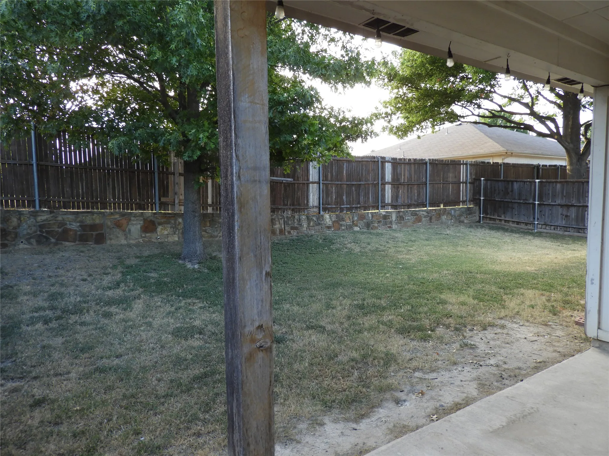 Spacious backyard with covered porch for covered enjoyment.
