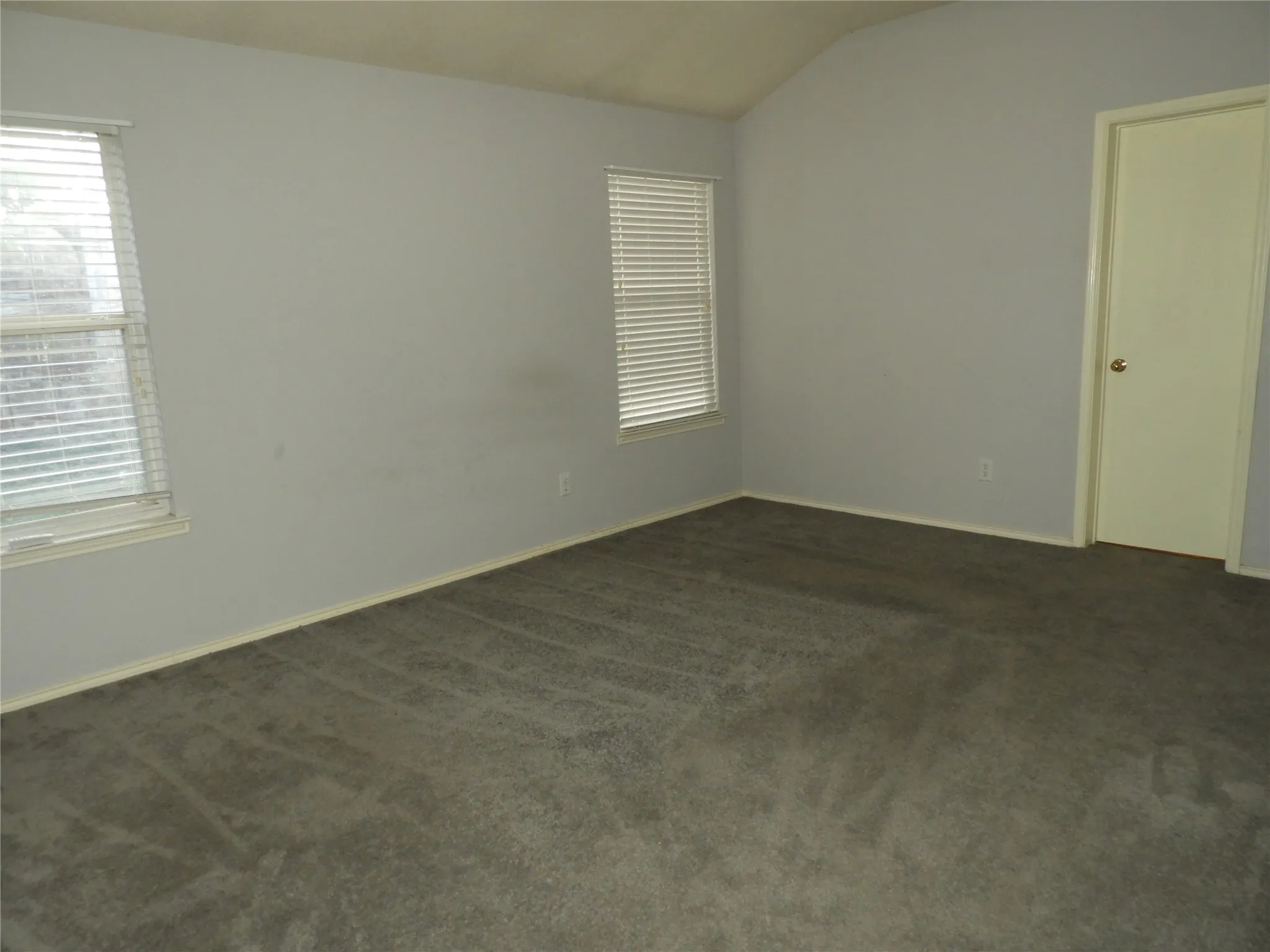 Primary Bedroom with lots of light, vaulted ceilings and brand new ceiling fan.