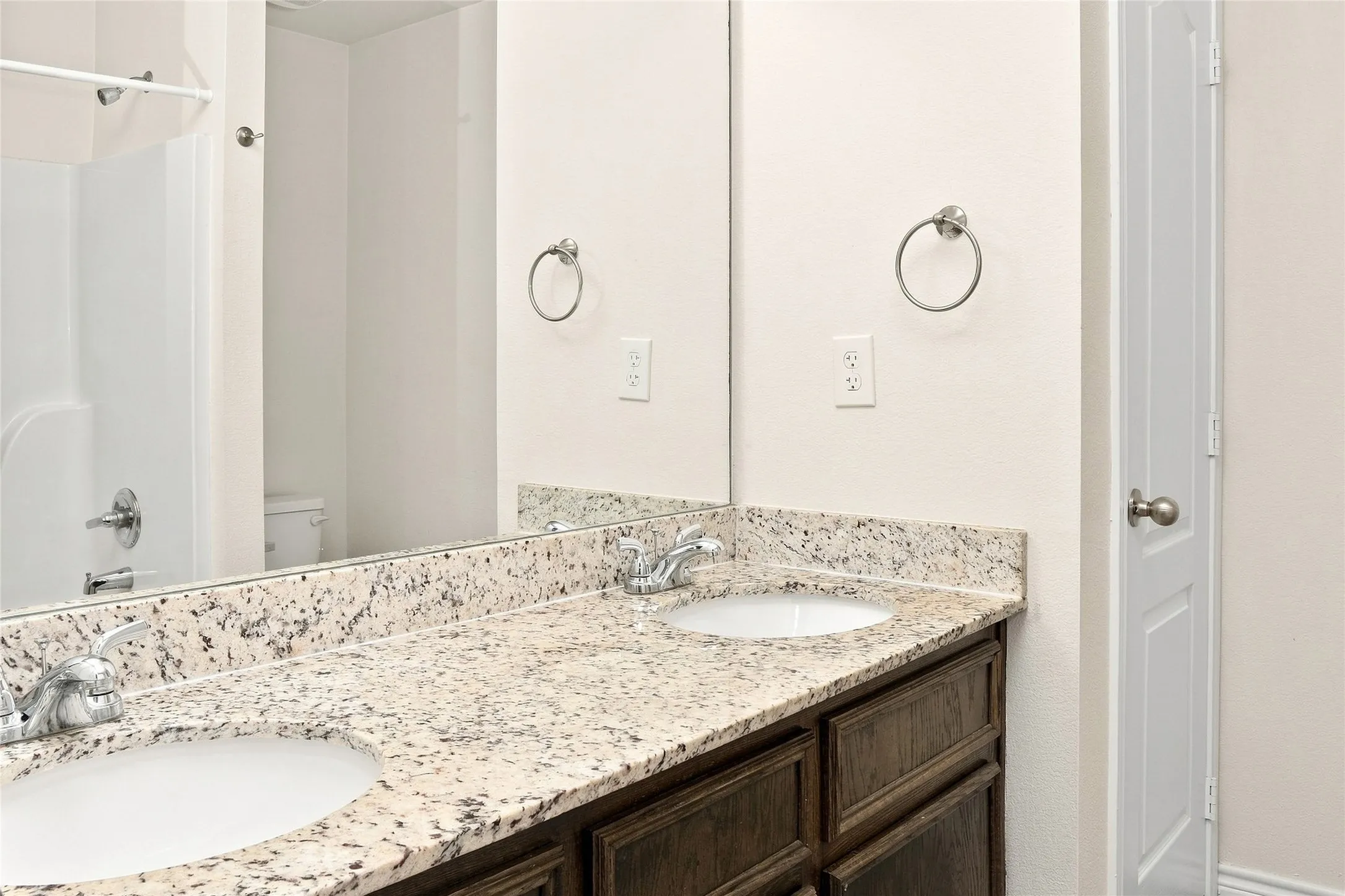 Dual vanity with granite countertops, undermount sinks, and chrome faucets