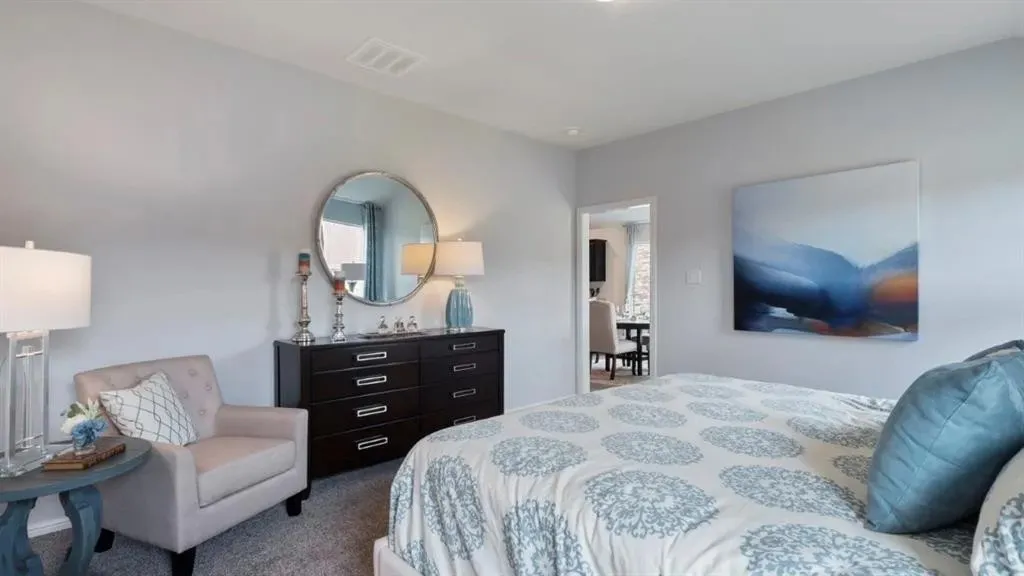Carpeted flooring, light gray walls, white ceiling, and a doorway opening to another room