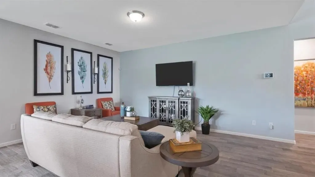 Wood-finish flooring throughout, light blue wall paint, and a built-in ceiling light fixture