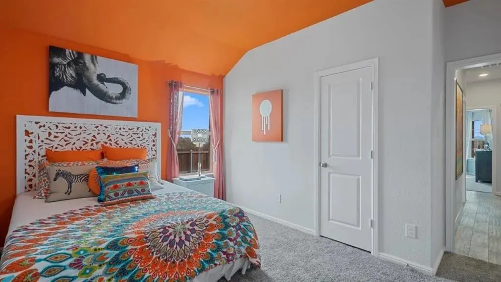 Vaulted ceiling with a vibrant accent, carpet flooring, a single window, and a paneled interior door