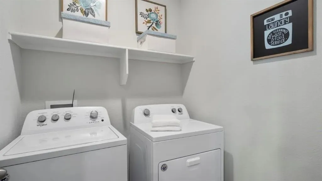 Laundry area with white walls, a white shelf, and a washer and dryer