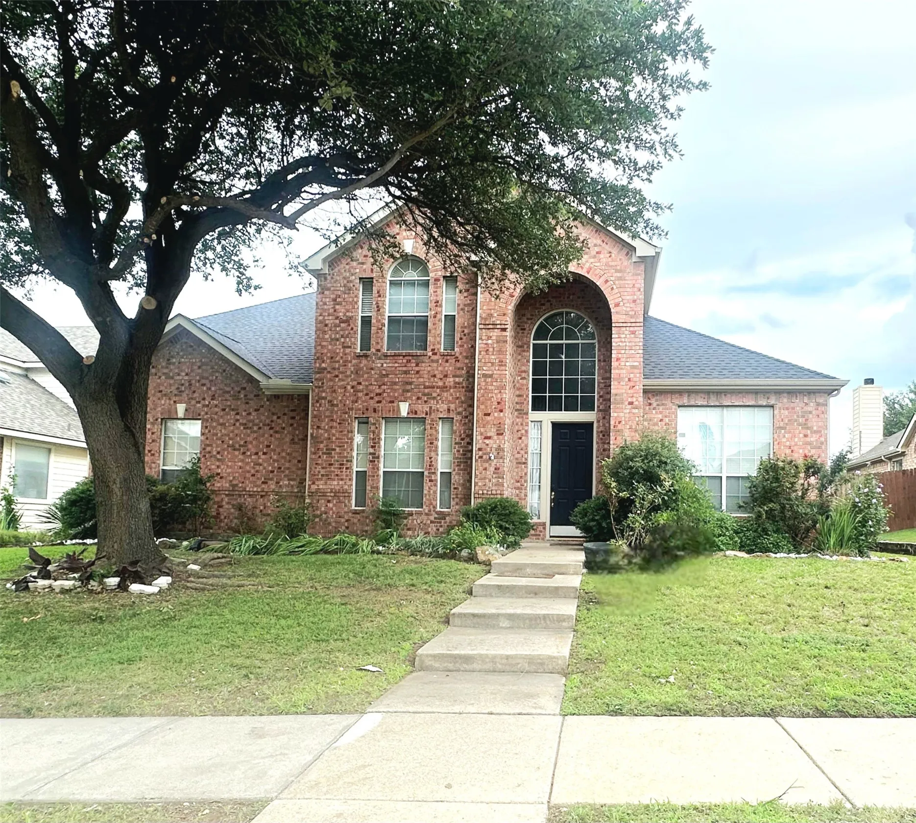 Brick exterior with arched entry and transom window