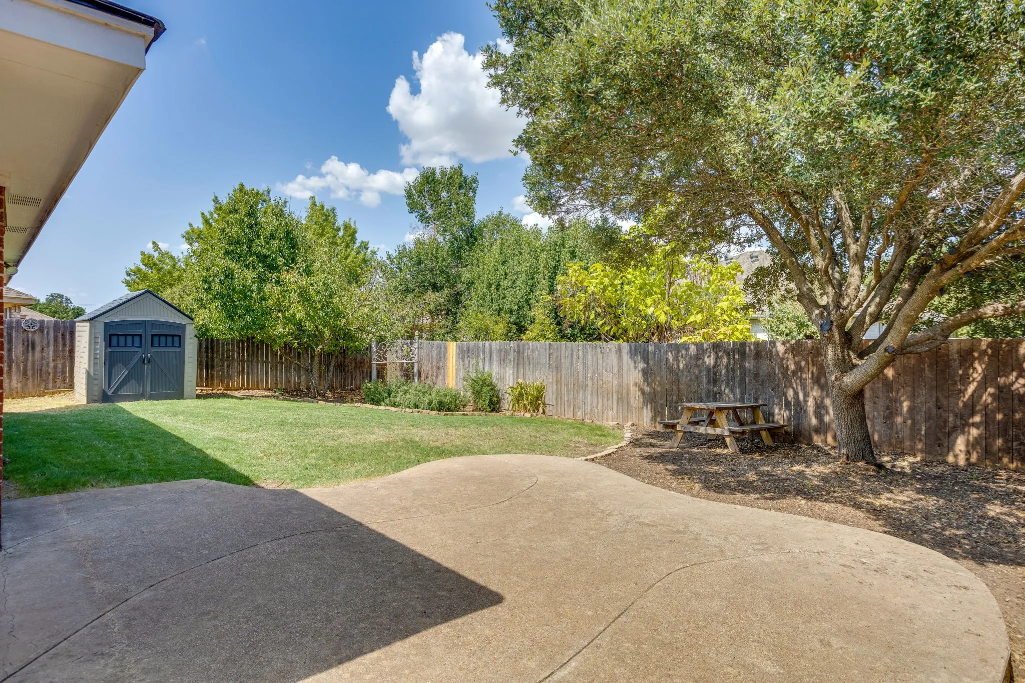 Large backyard with shec and large patio