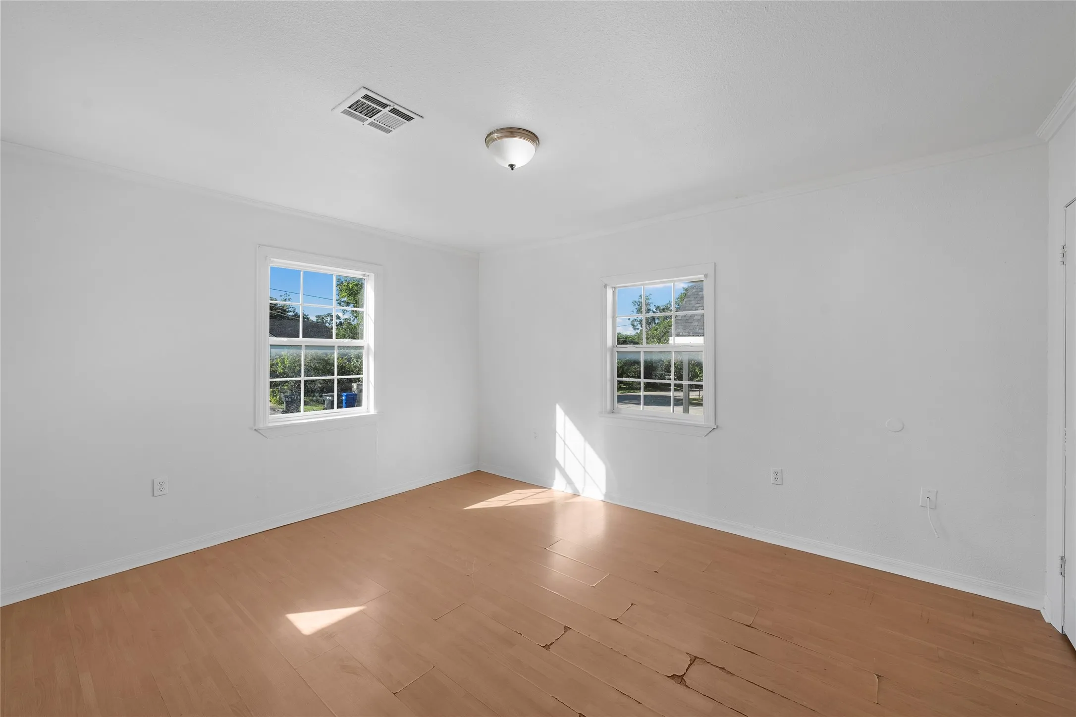 Unfurnished room with crown molding and wood finished floors