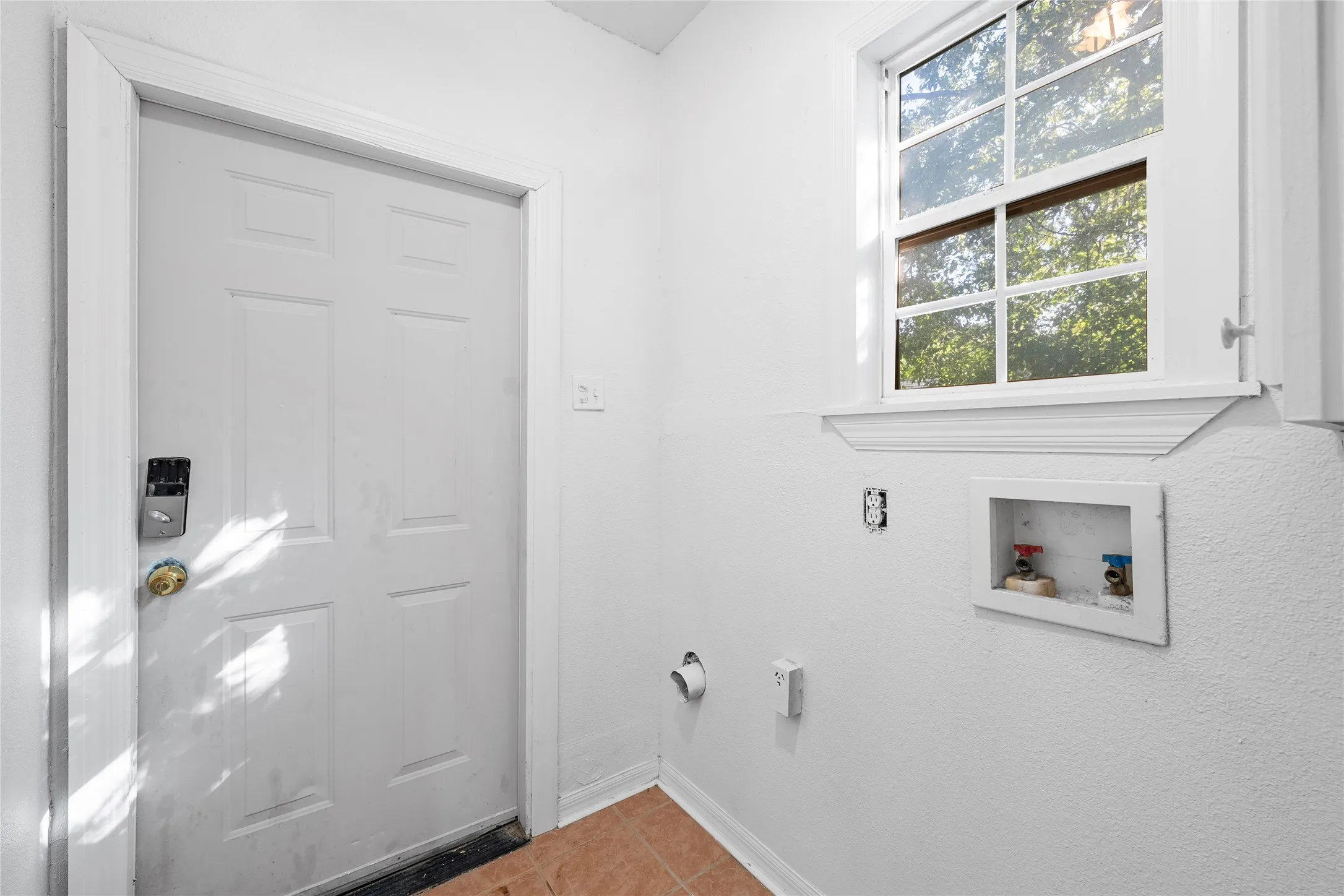Laundry room featuring washer hookup and tile patterned flooring