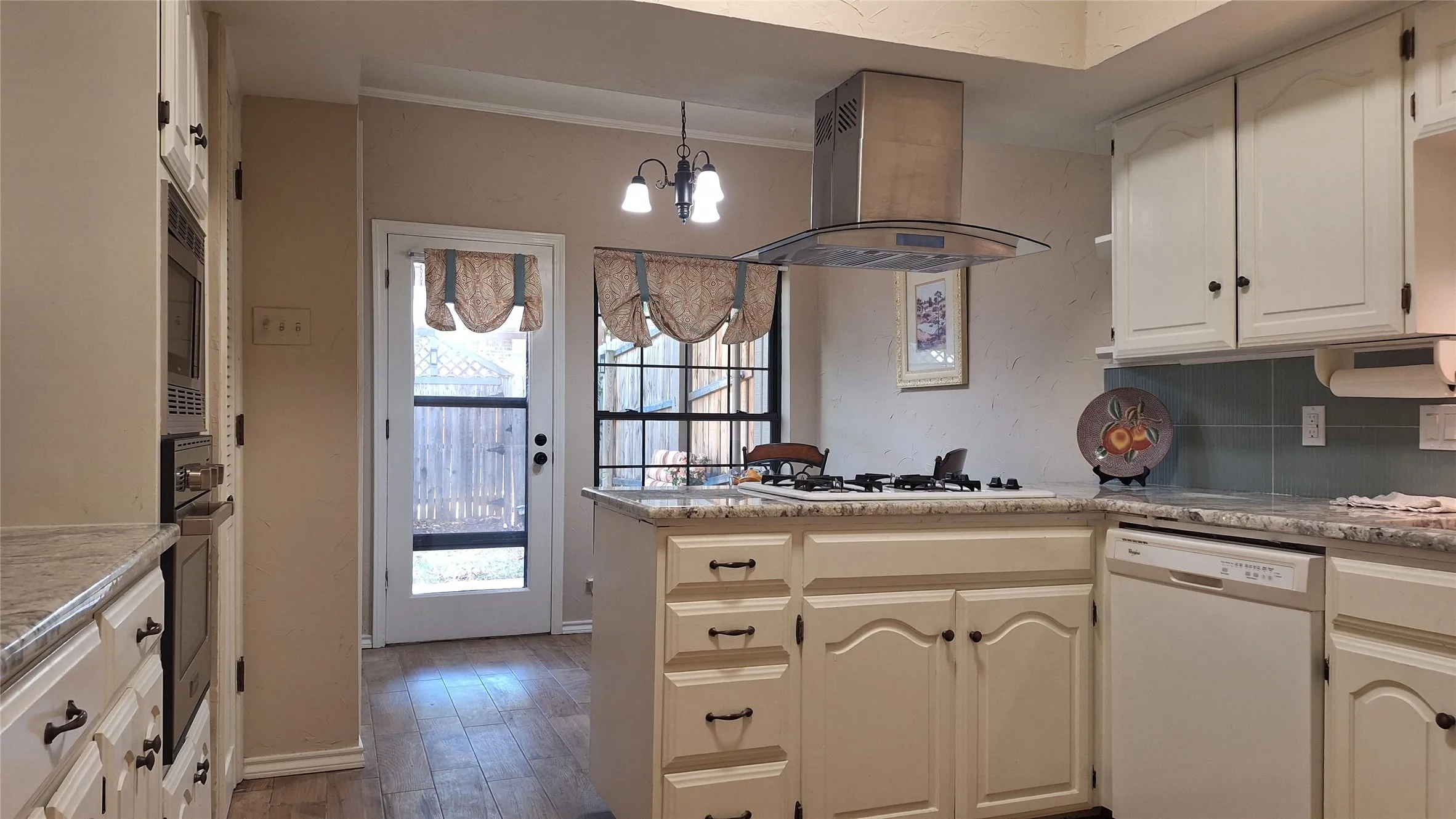 gas cooktop in breakfast bar and door to back patio & deck