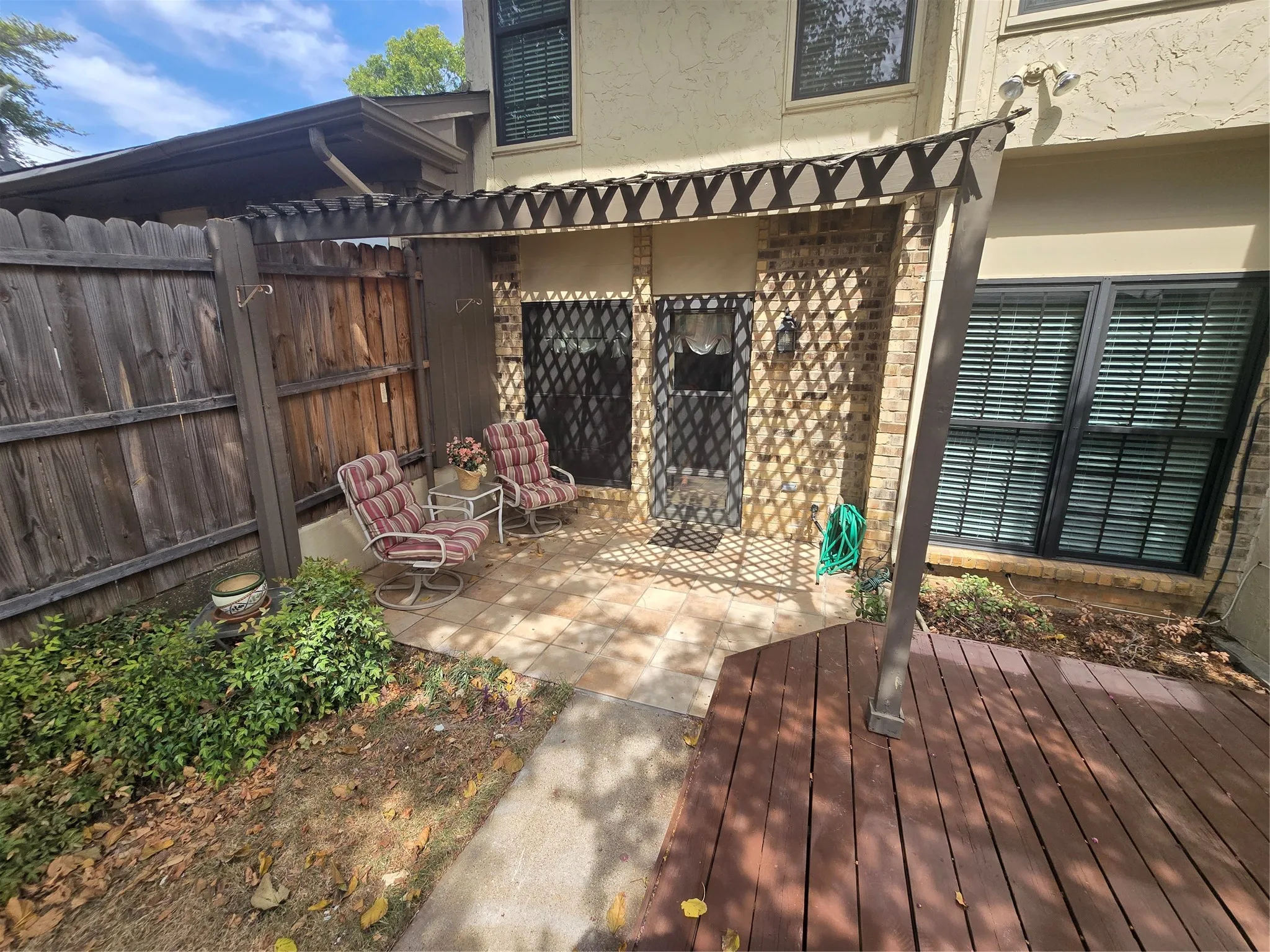 covered porch off breakfast room with sidewalk between dog run & deck