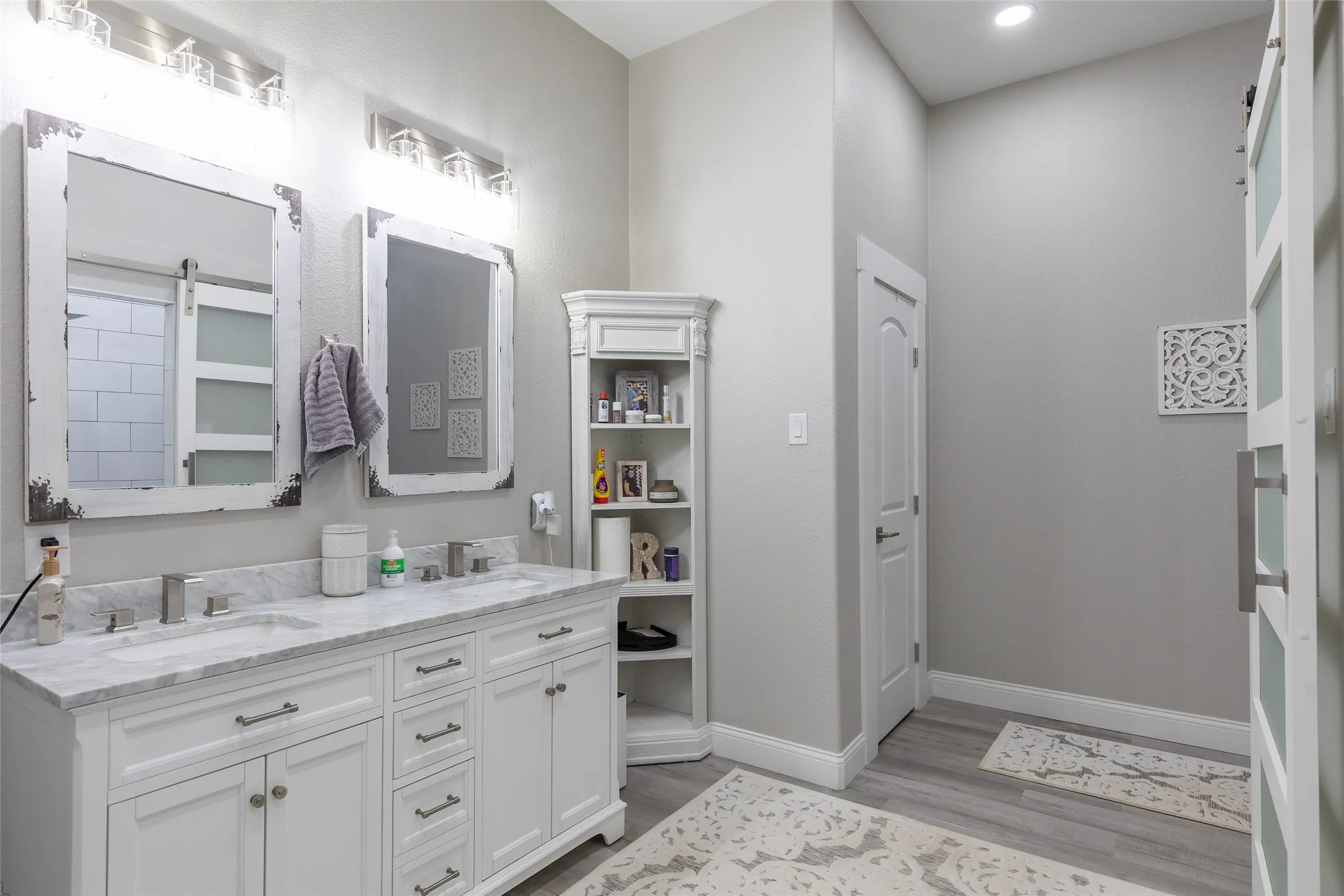 Dual vanity with white cabinetry, undermount sinks, and stone countertop