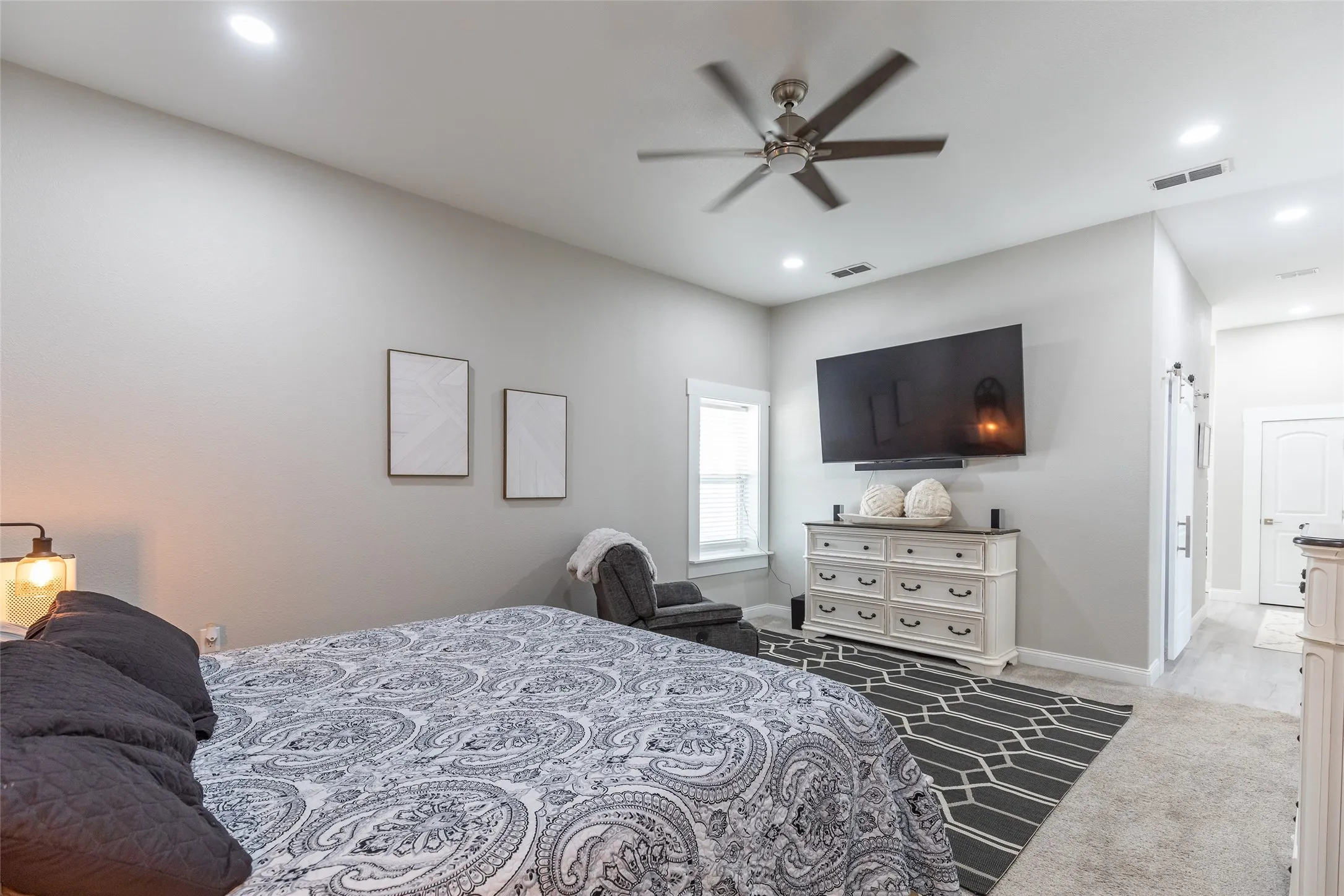 Spacious primary bedroom featuring neutral wall finishes, recessed lighting, and a ceiling fan