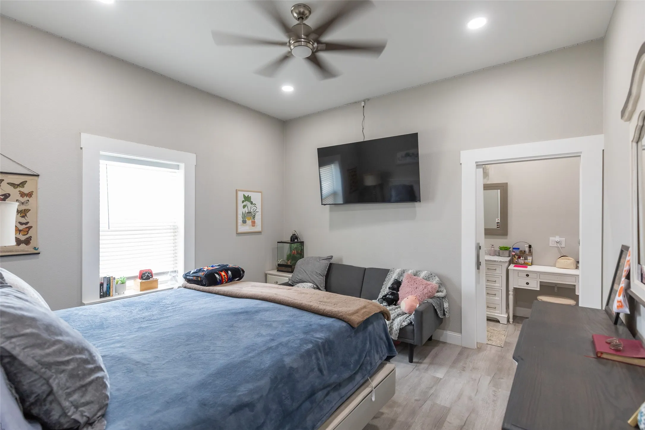Spacious room featuring light wood-finish flooring, recessed lighting, and a ceiling fan
