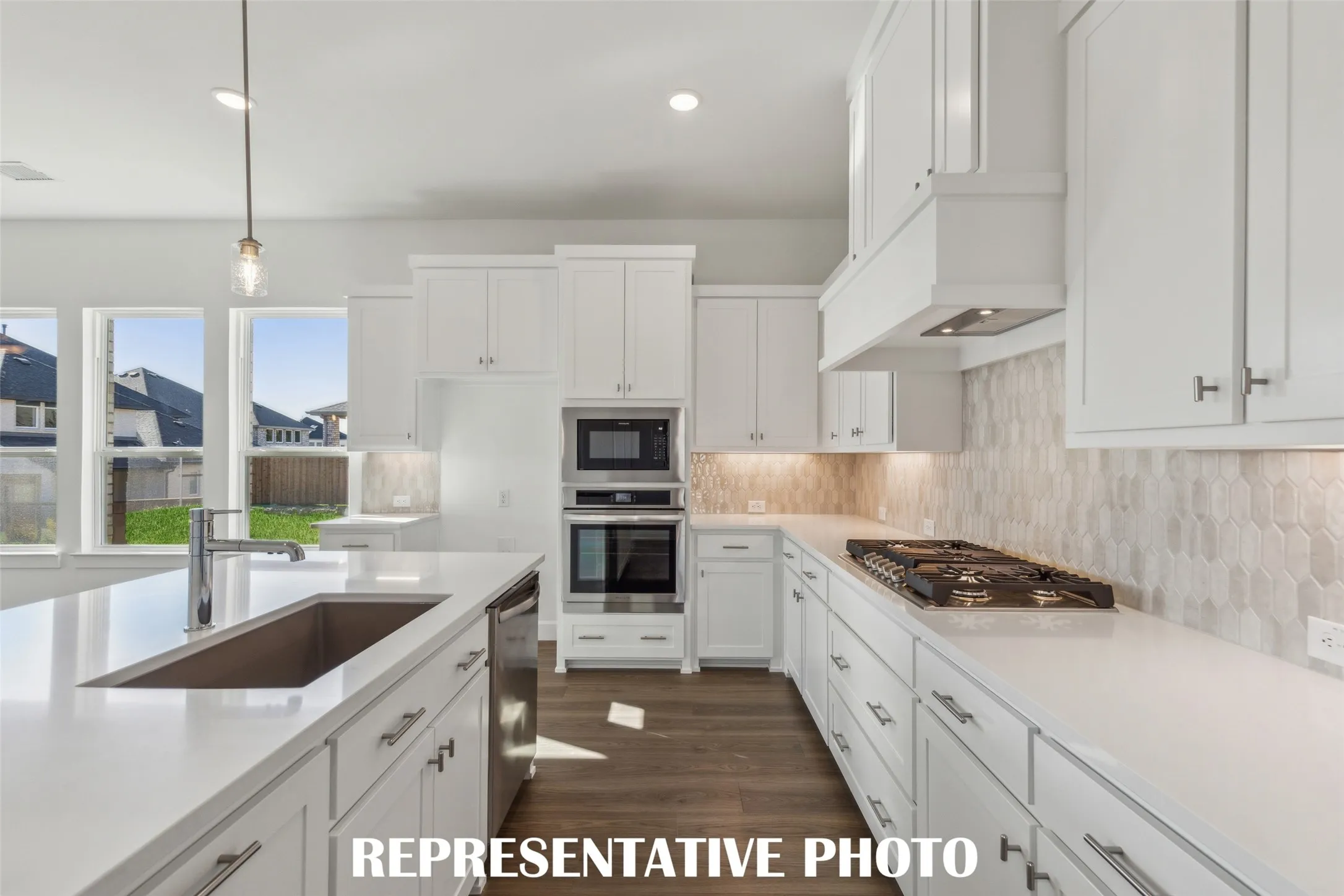 Beautiful cabinetry, gorgeous countertops and designer backsplash effortlessly pair with contemporary stainless steel to create a kitchen for the ages!  REPRESENTATIVE PHOTO
