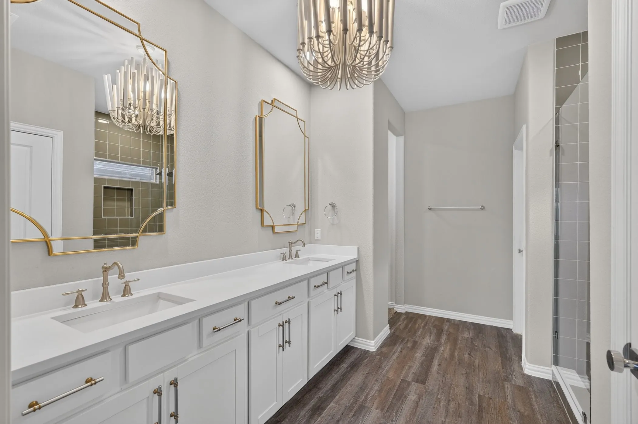 Glass-enclosed shower with square wall tiling, rain shower head, handheld shower fixture, and a built-in niche