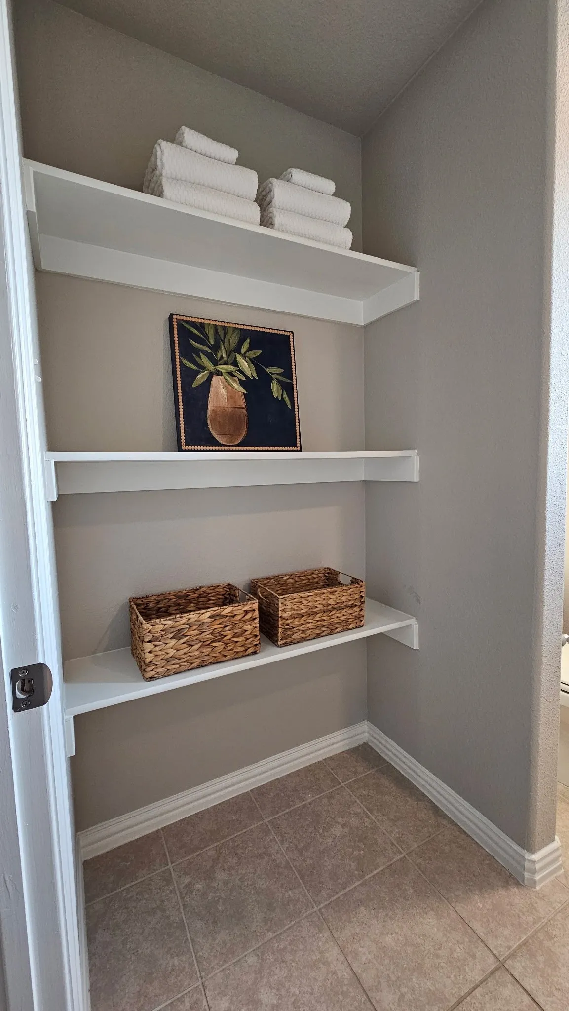Built-in shelving with neutral wall paint and tile flooring