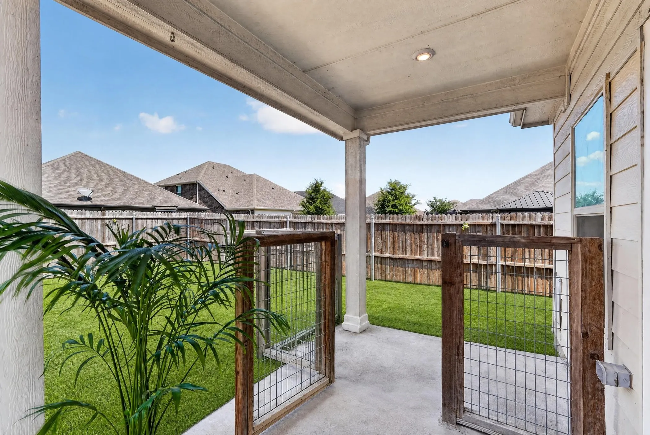 Vaulted ceilings with recessed lighting, wood-finish flooring, white cabinetry with gold-tone hardware, kitchen island with sink, and stainless steel range with hood