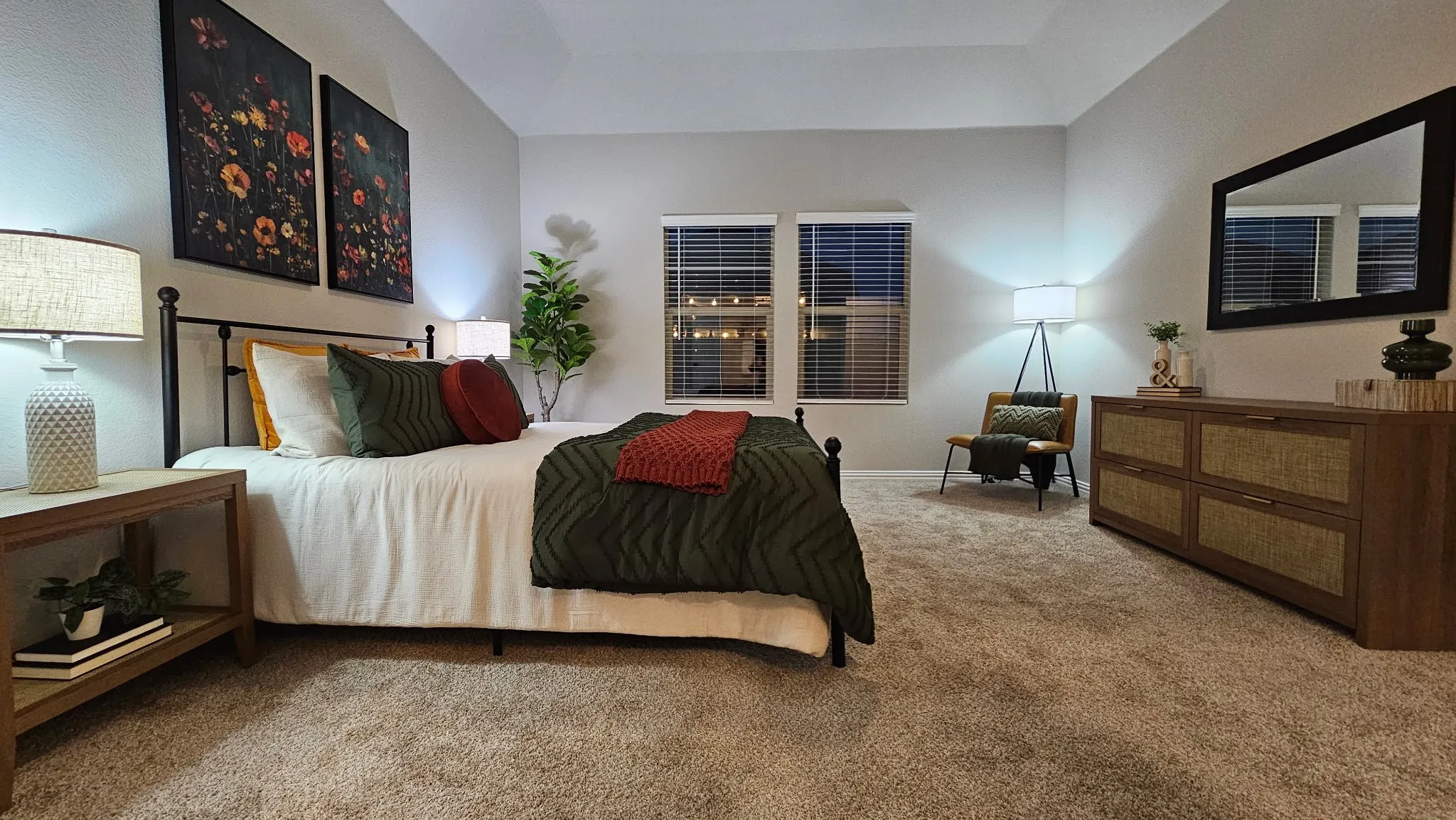 Carpeted bedroom featuring a vaulted ceiling and dual windows with blinds