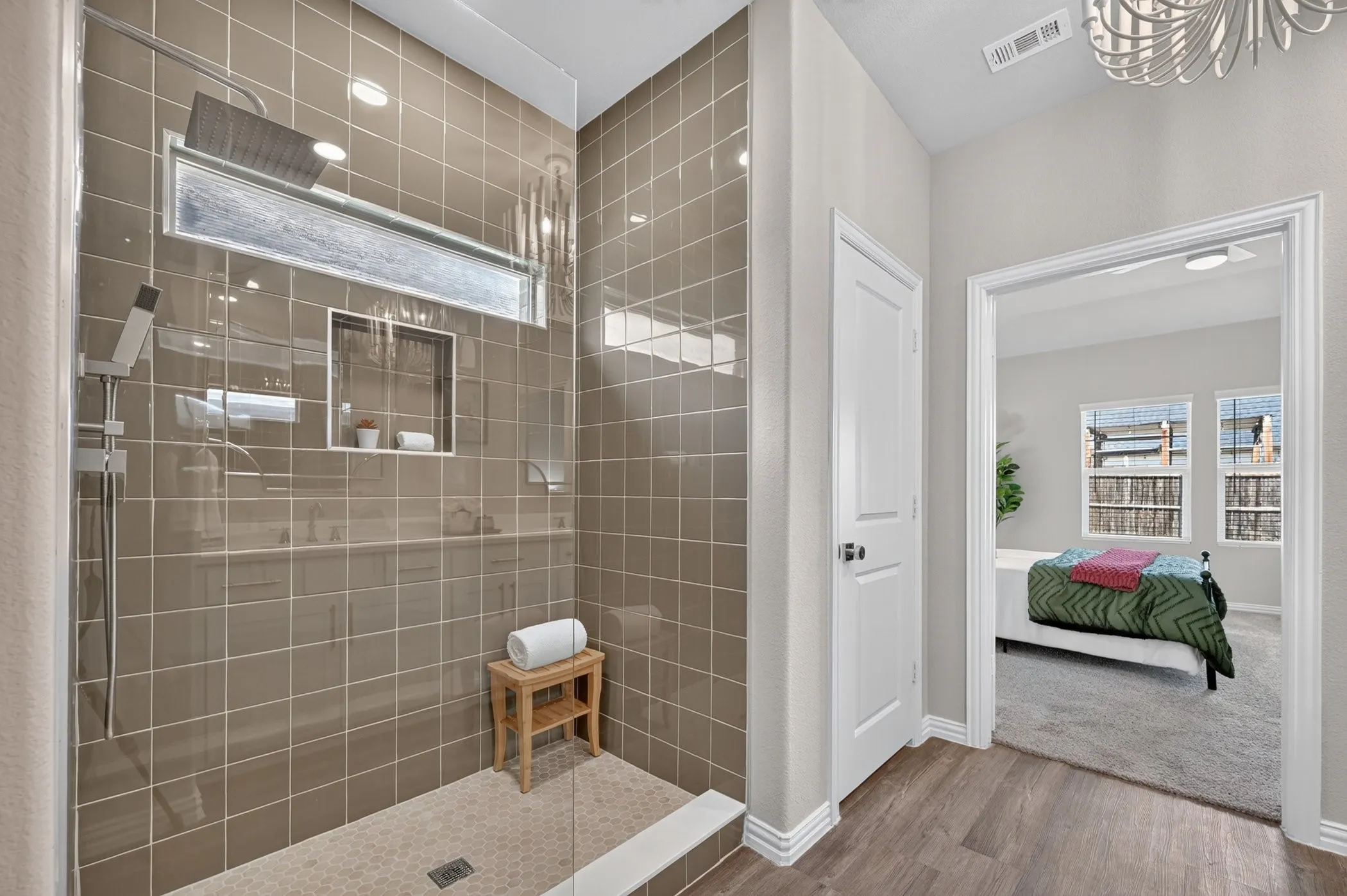Walk-in shower with full-height tile surround, built-in niche, and overhead rain shower