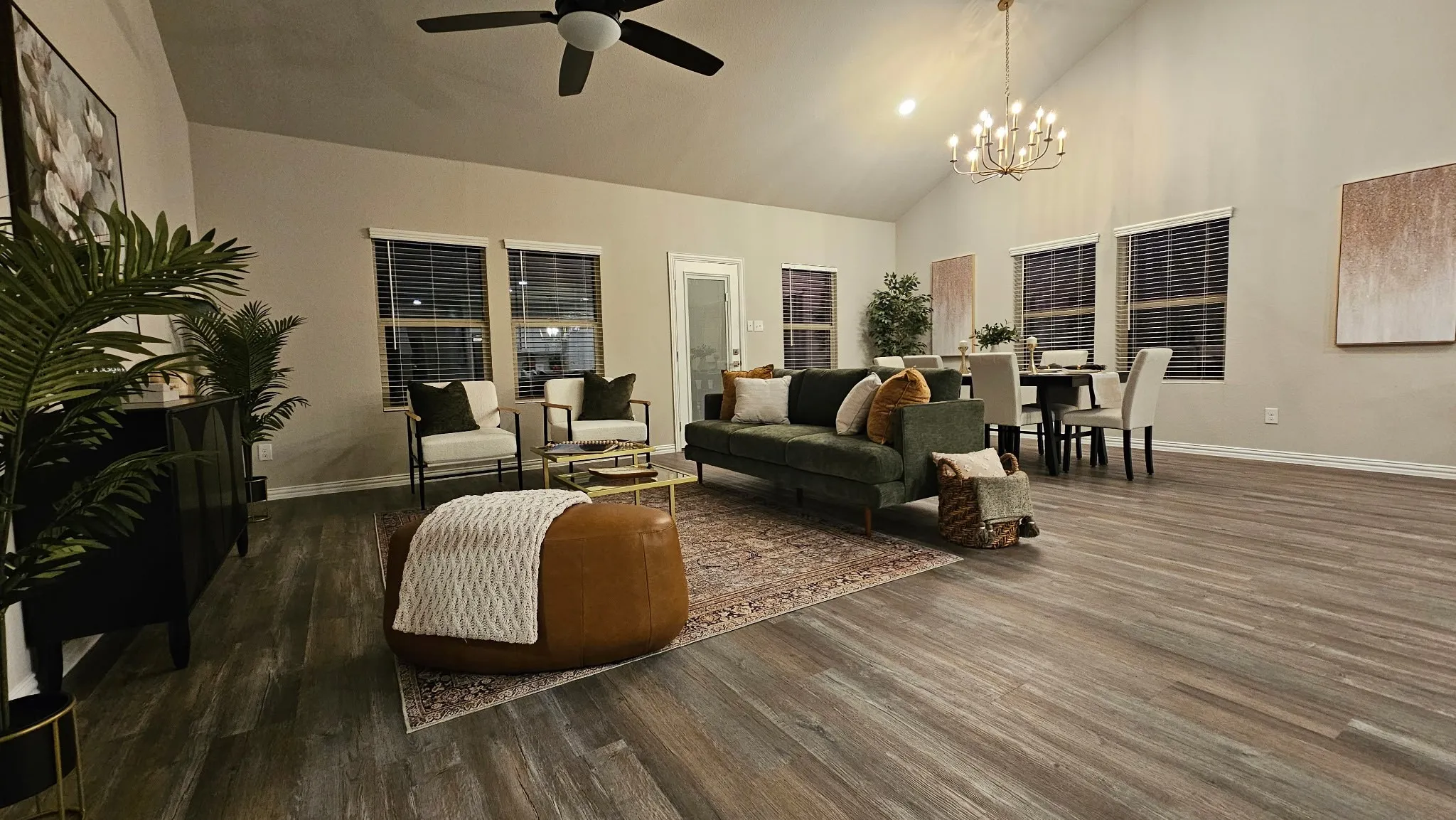 Vaulted ceiling with an overhead fan, wood-finish flooring, and multiple windows with blinds