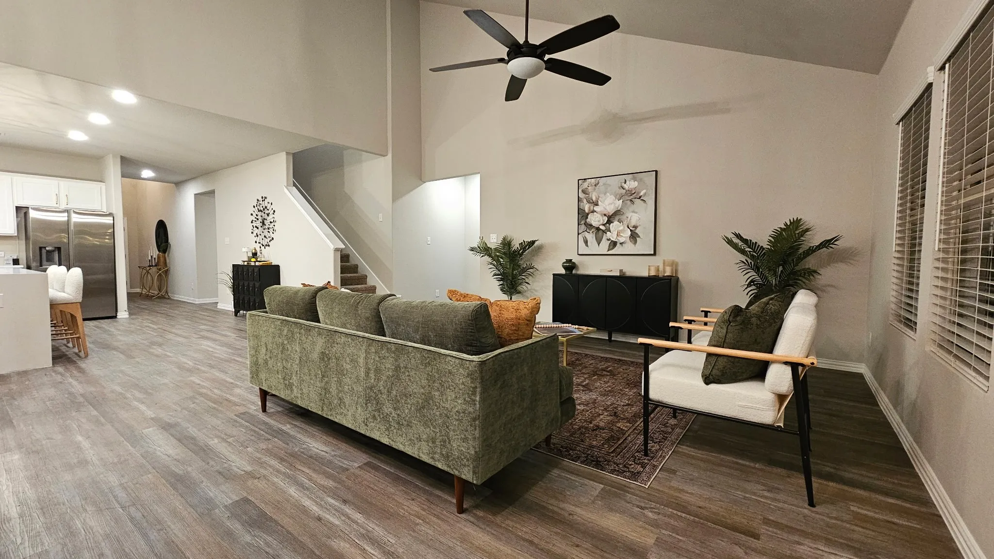 Vaulted ceiling with a ceiling fan, recessed lighting, wood-finish flooring, and white window blinds