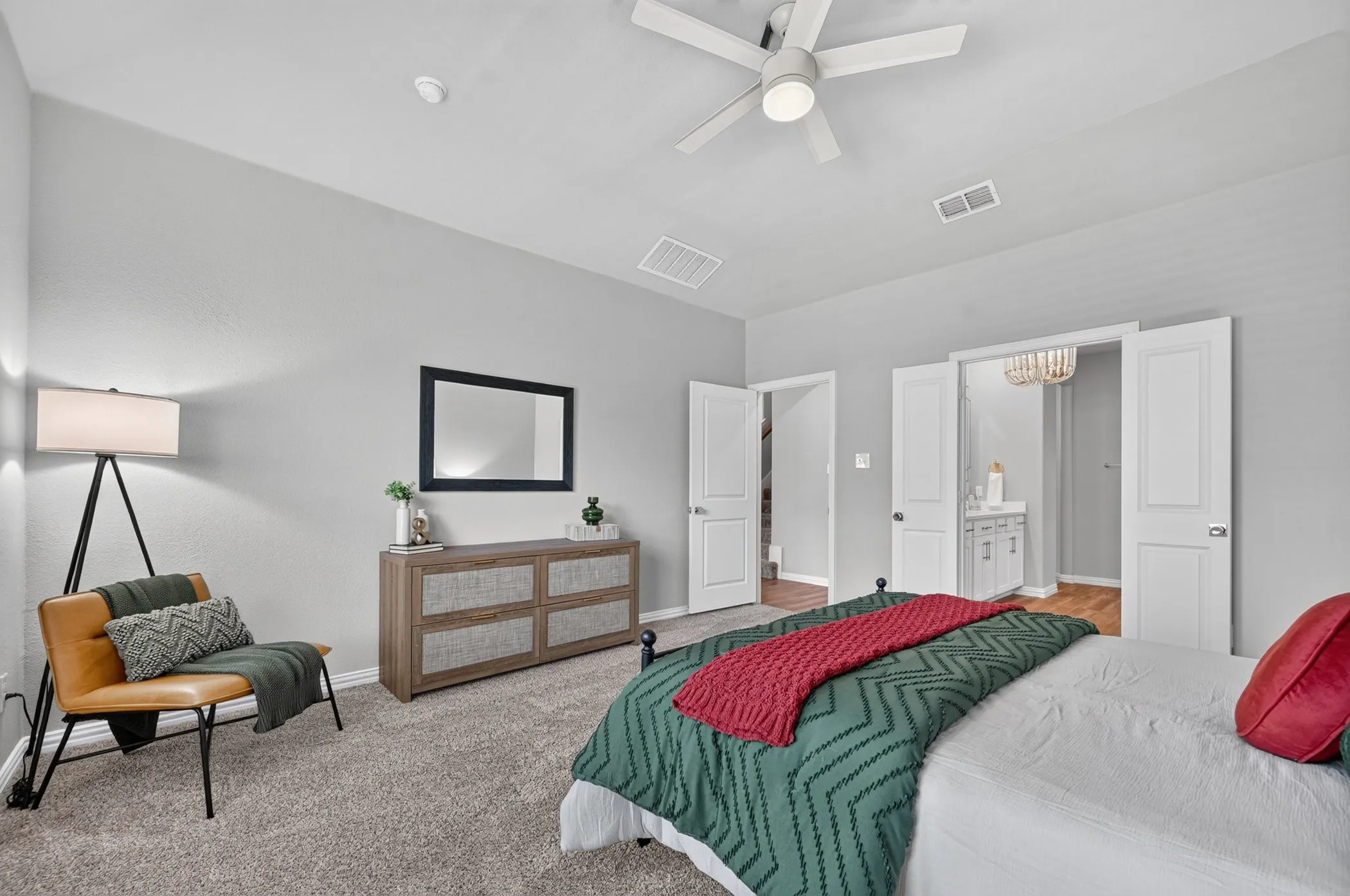 Vaulted ceilings, carpet flooring, ceiling fan with light fixture, and double doors to additional space