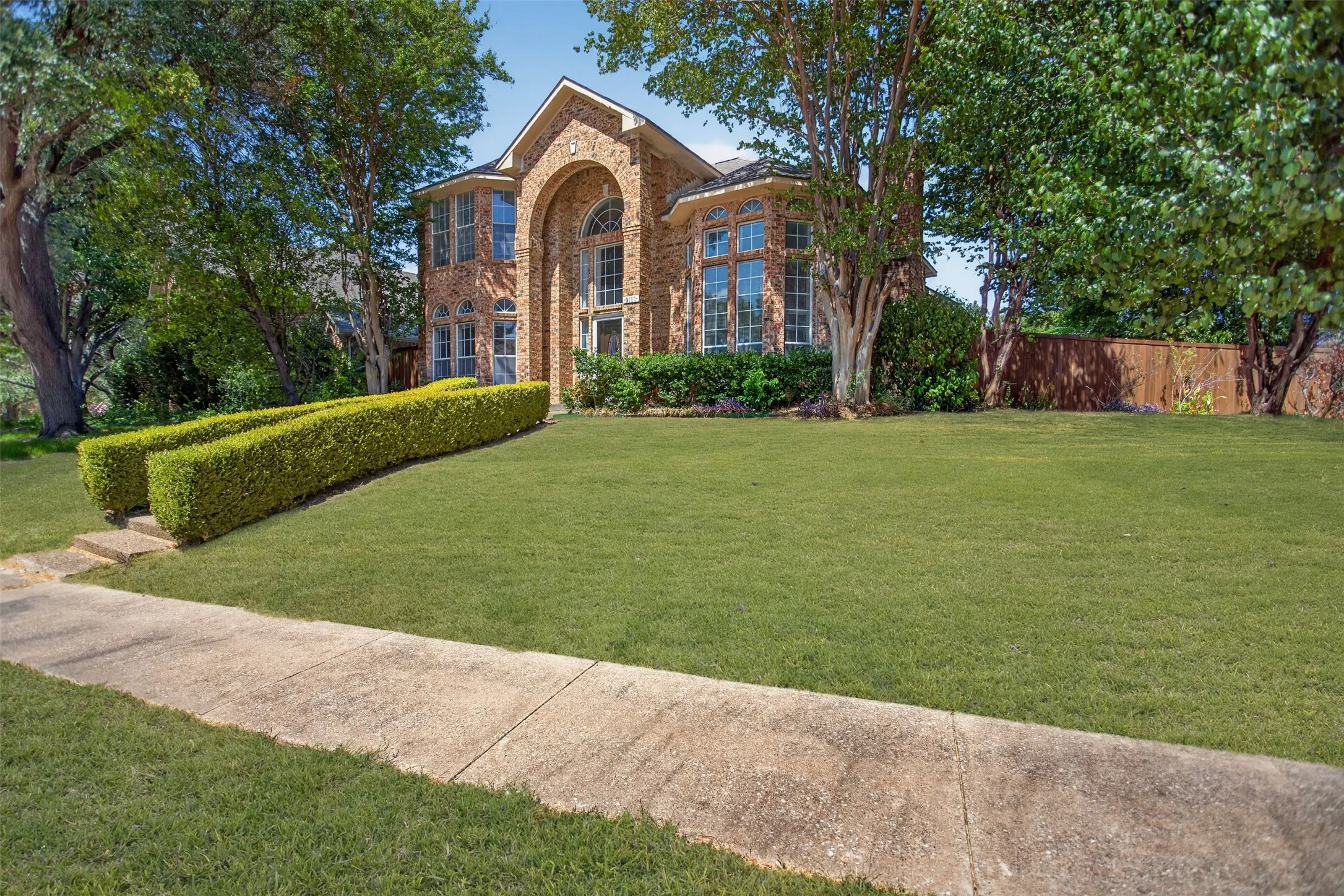Brick-clad exterior with arched entryway and multiple window designs