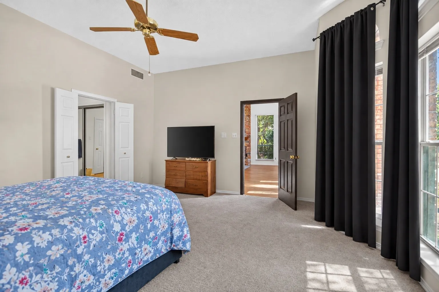 Vaulted ceiling, ceiling fan, carpet flooring, large window, and paneled interior doors