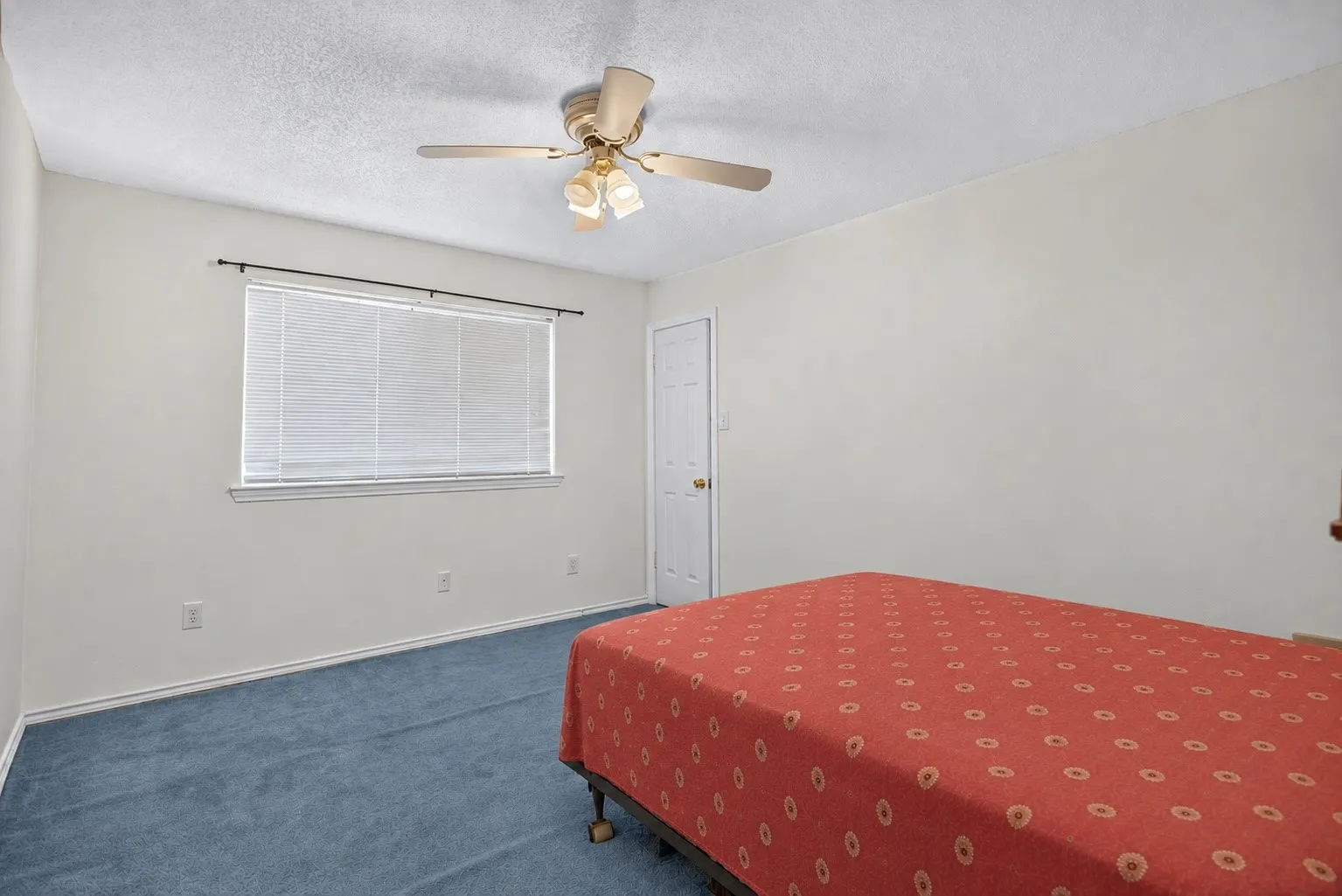 Carpeted flooring, ceiling fan with integrated lighting, window with blinds, and a white paneled door
