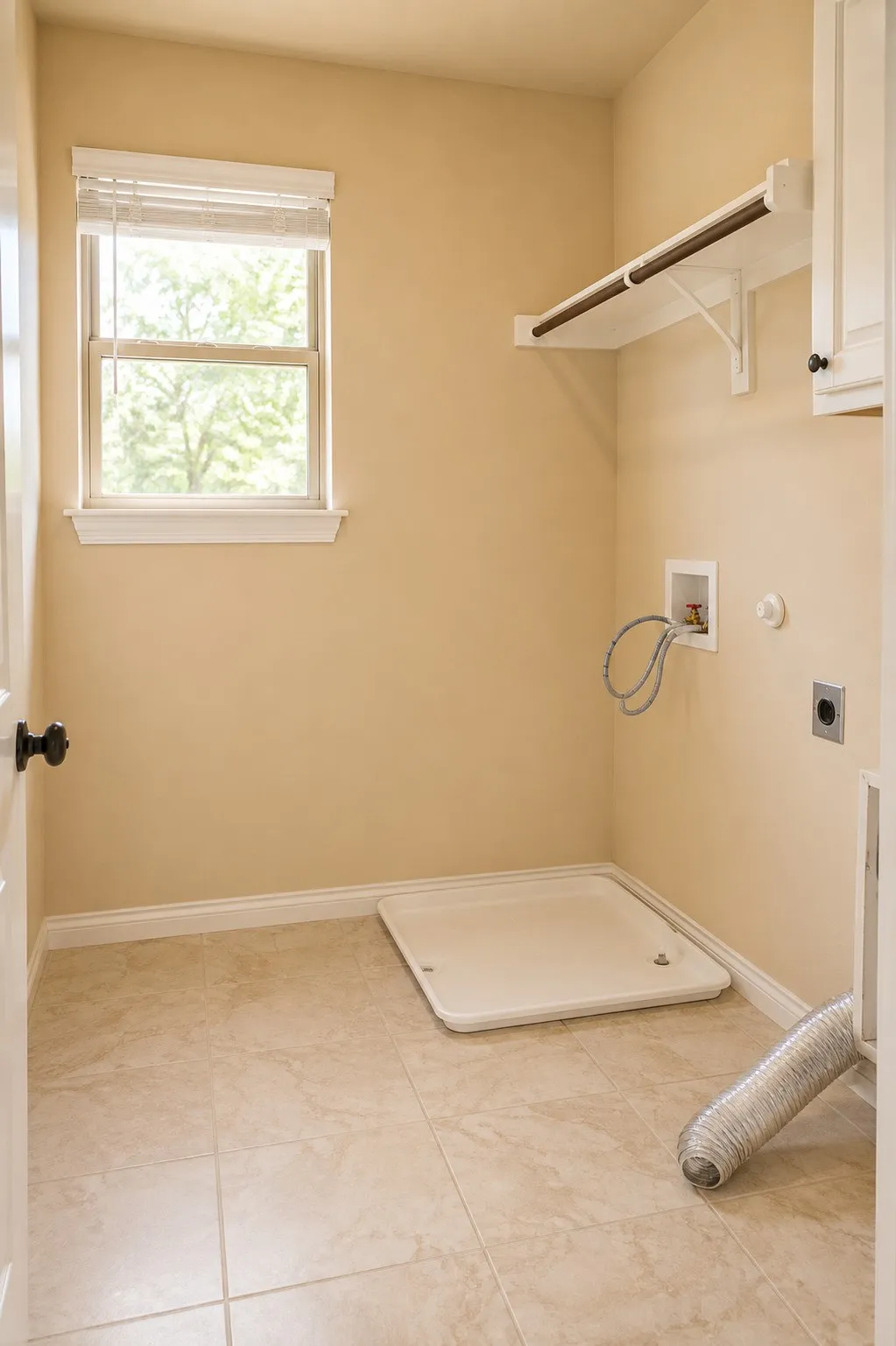 Laundry area featuring tile flooring, built-in shelving with a hanging rod, a window with blinds, and white cabinetry