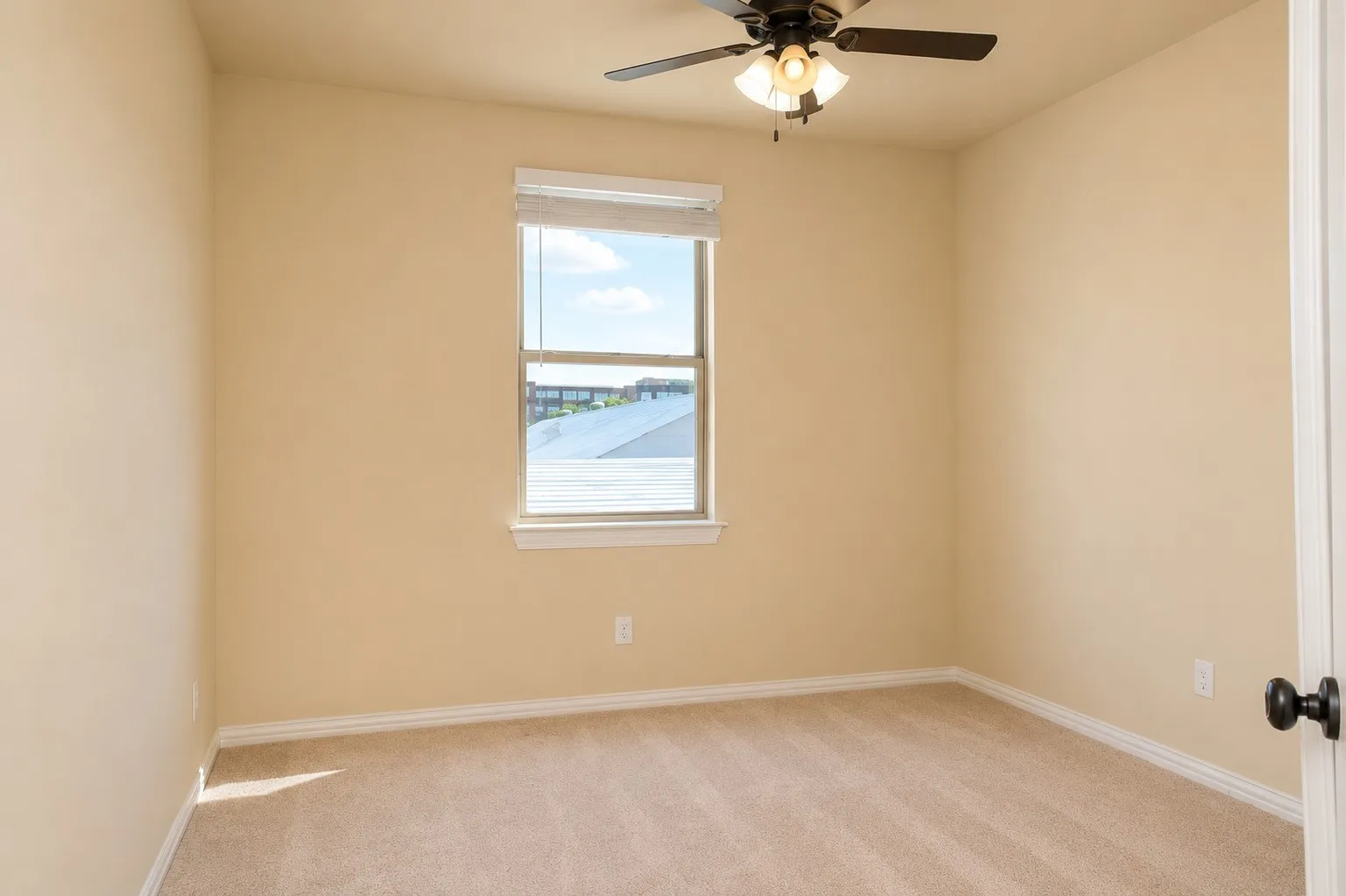 Neutral tone wall paint with a window, carpet flooring, and a ceiling fan with light fixture