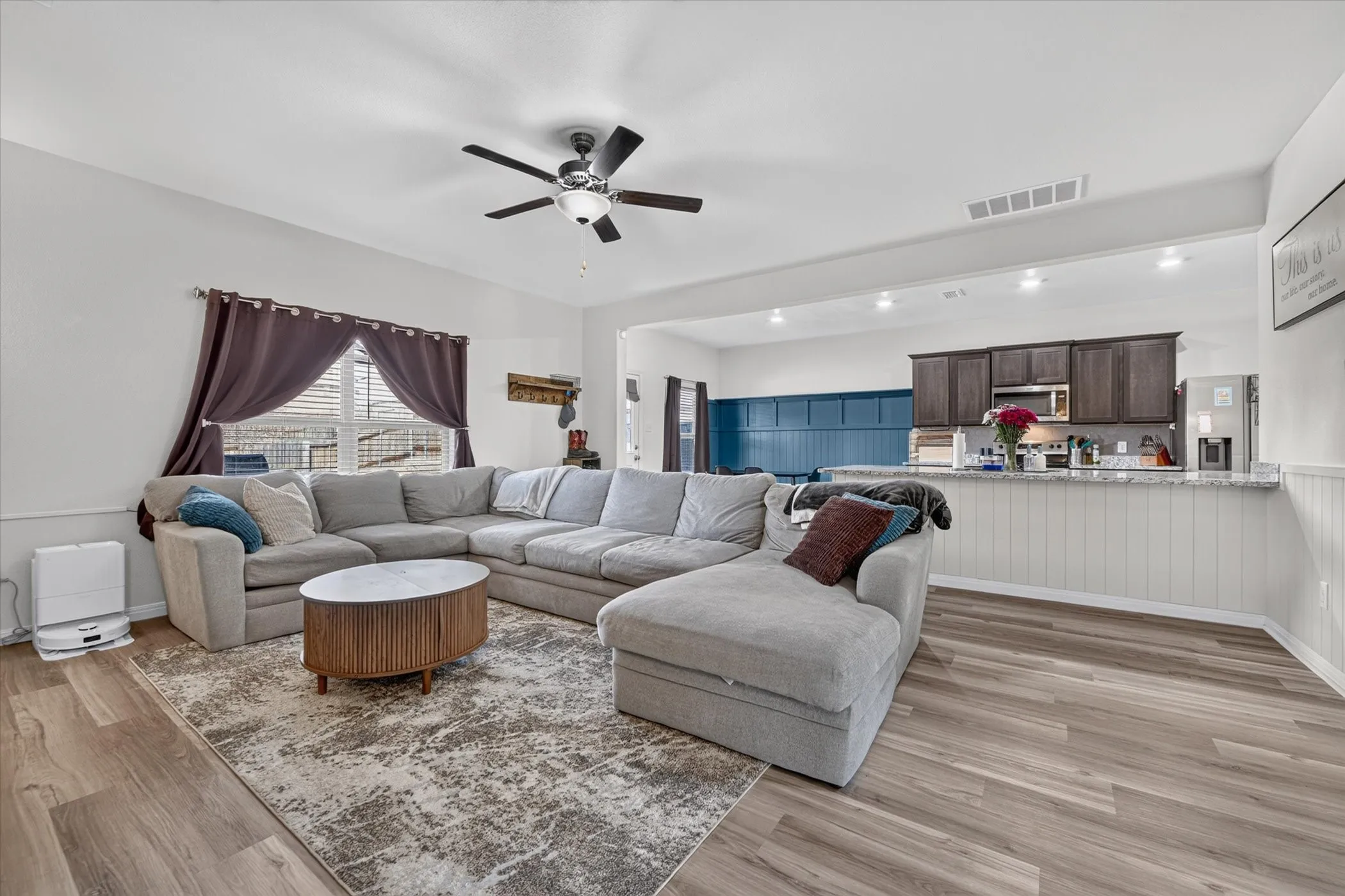 Vaulted ceiling with ceiling fan, wood-finish flooring, white wainscoting, and recessed lighting