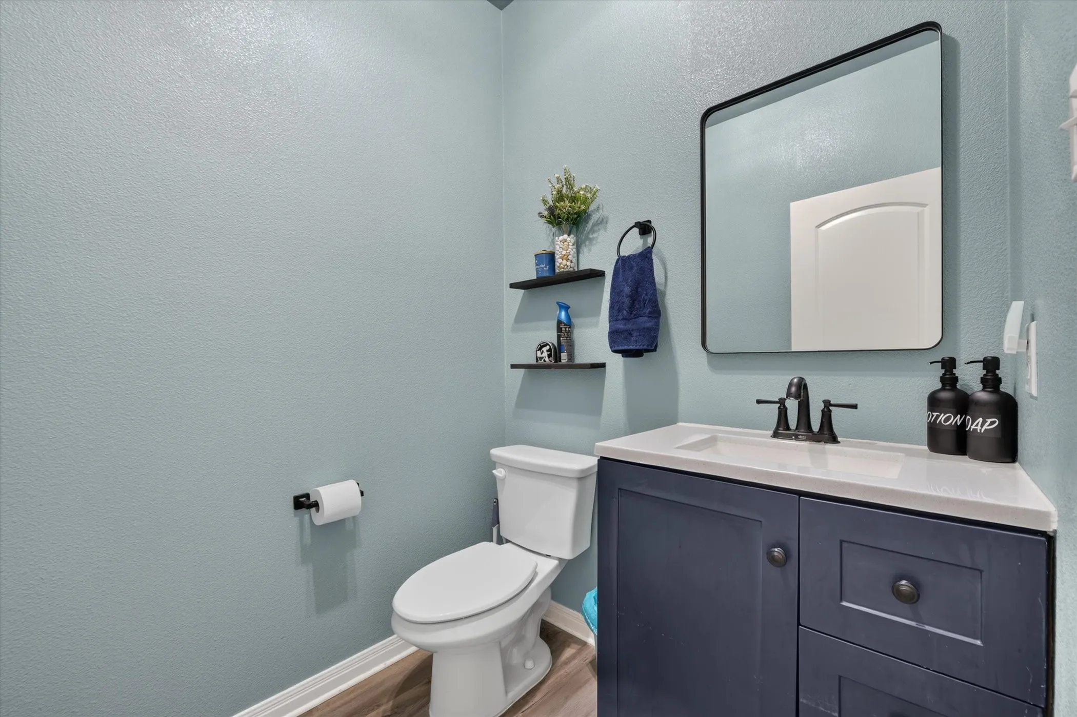 Floating vanity with a light-colored countertop, integrated sink, and dark-toned cabinetry