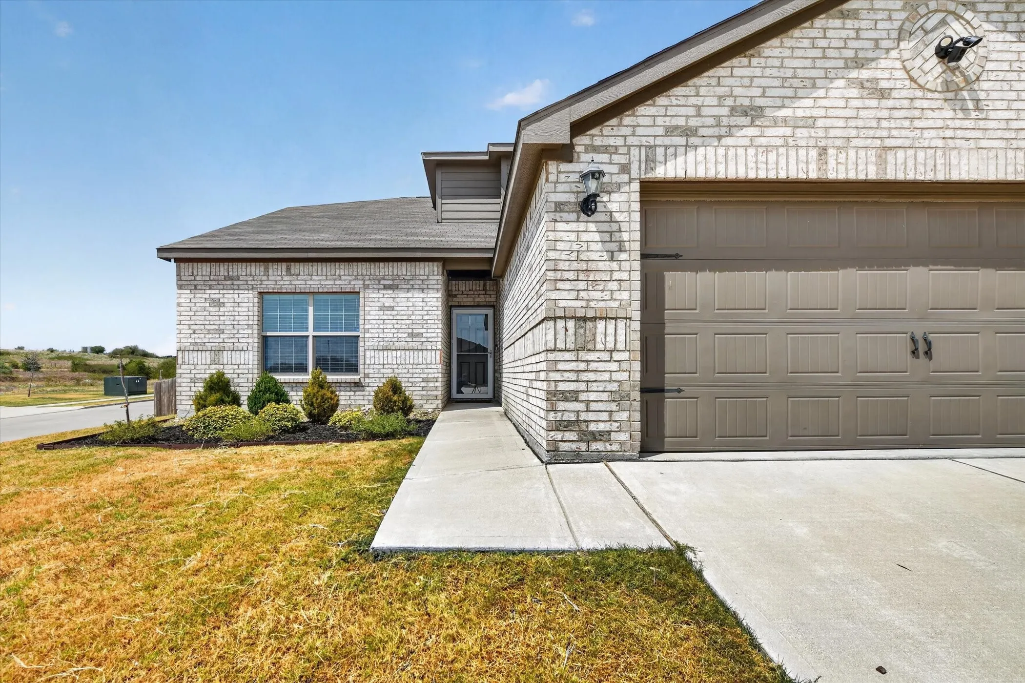 White brick exterior with a two-car garage