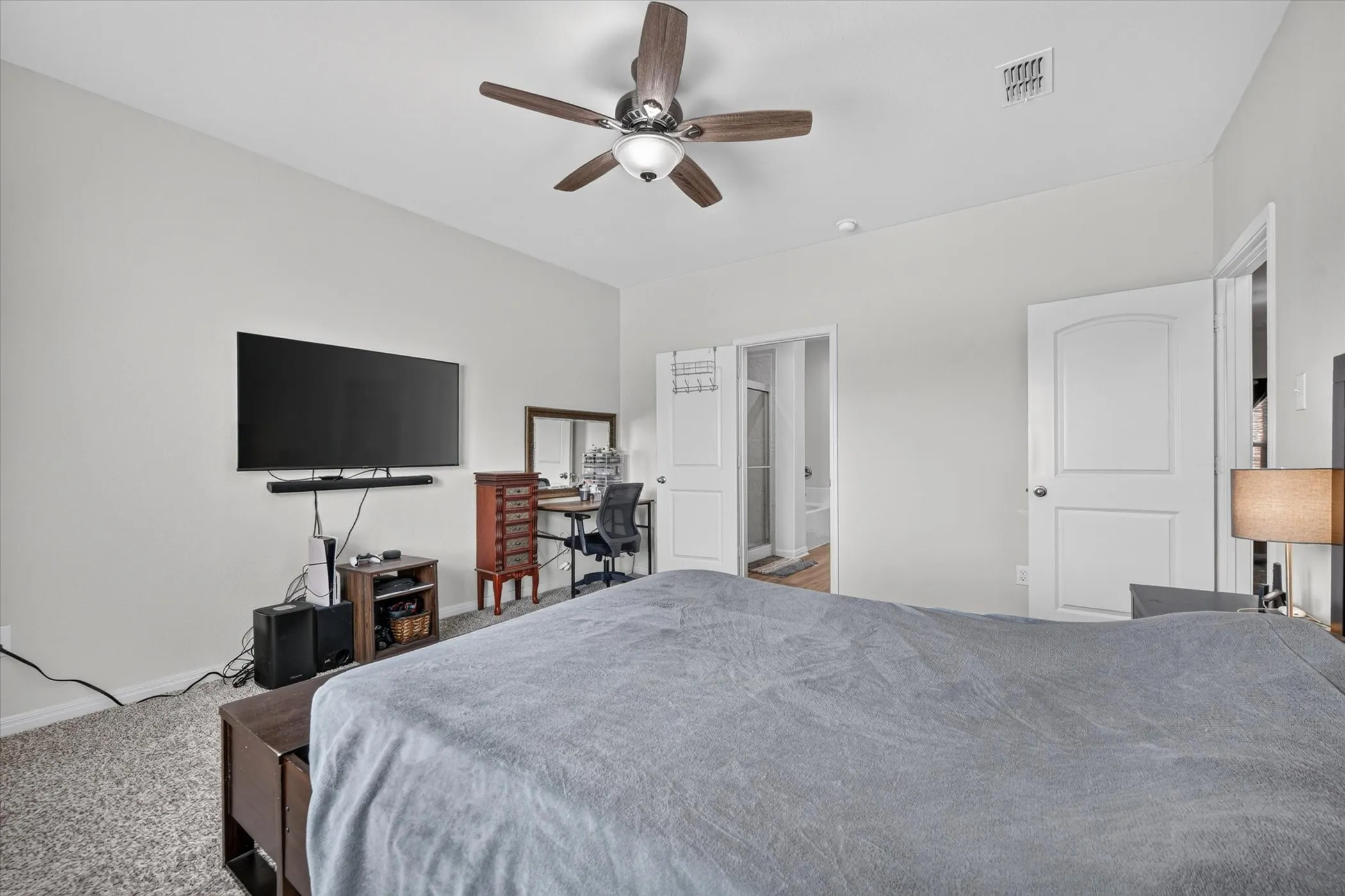 Recessed ceiling fan with wood-finish blades, light gray wall paint, and white paneled doors