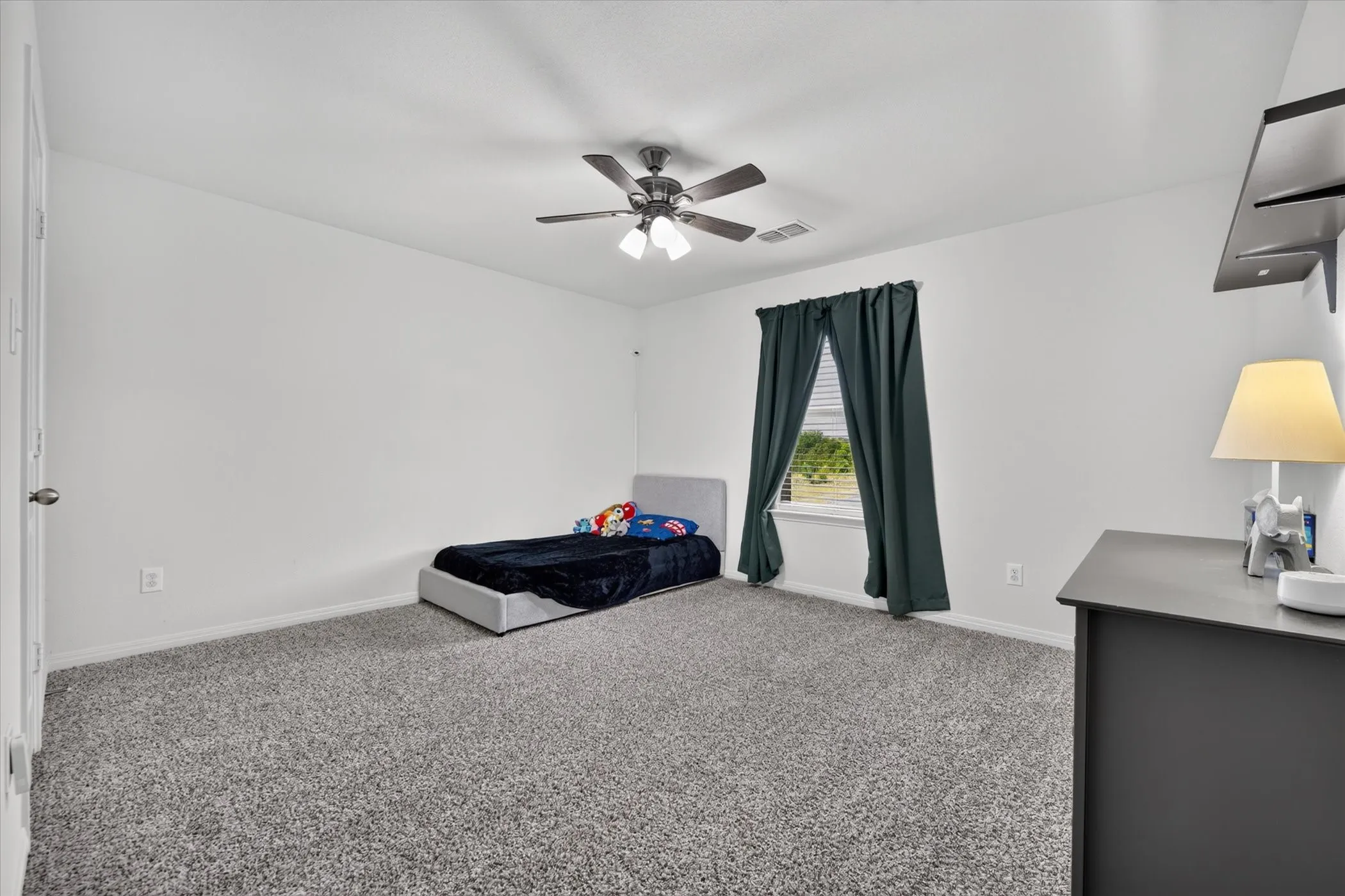 Wall-to-wall carpeting and a ceiling fan with integrated lighting